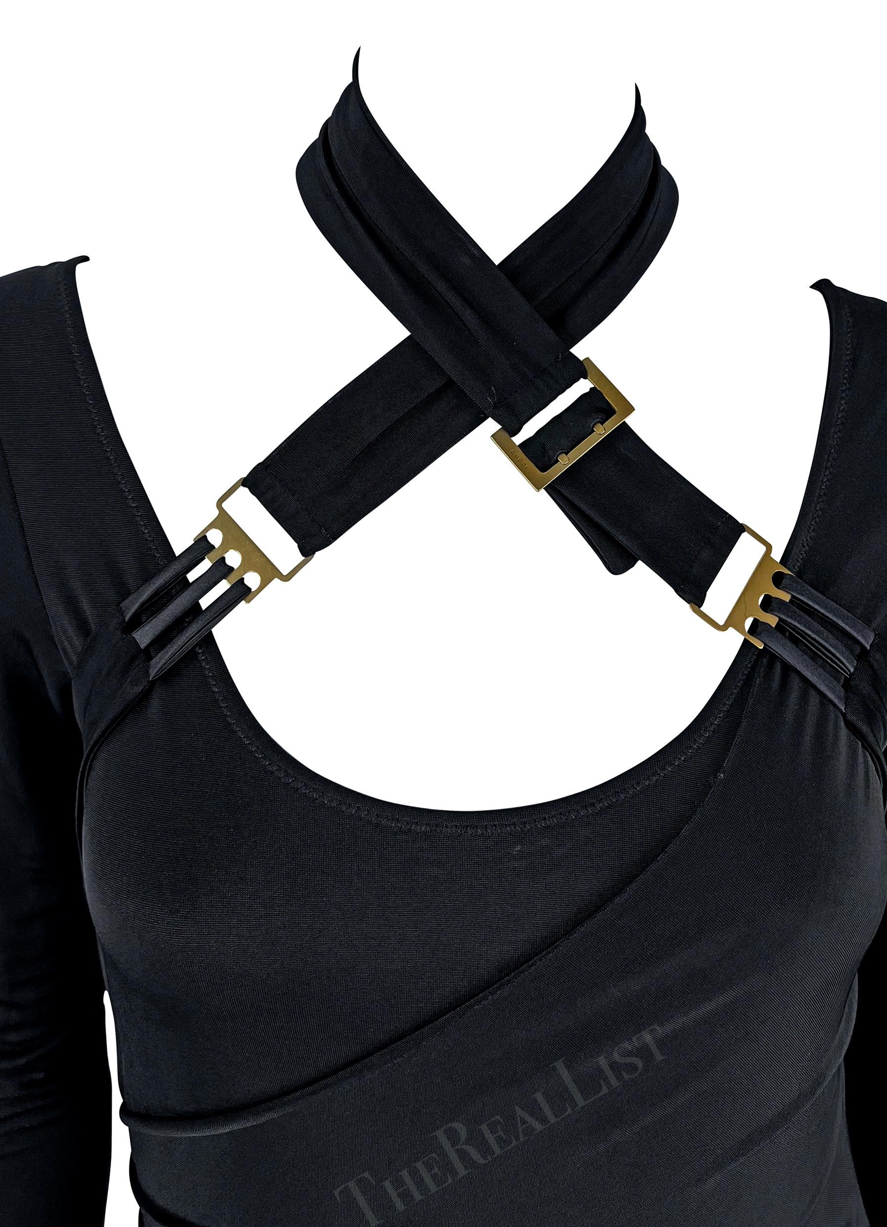Presenting a fabulous black Gucci bodycon dress, designed by Tom Ford. From the Fall/Winter 2003 collection, this dress features long sleeves, a knee-length hem, and a low scoop neckline. Made complete with belt buckles that can be wrapped around
