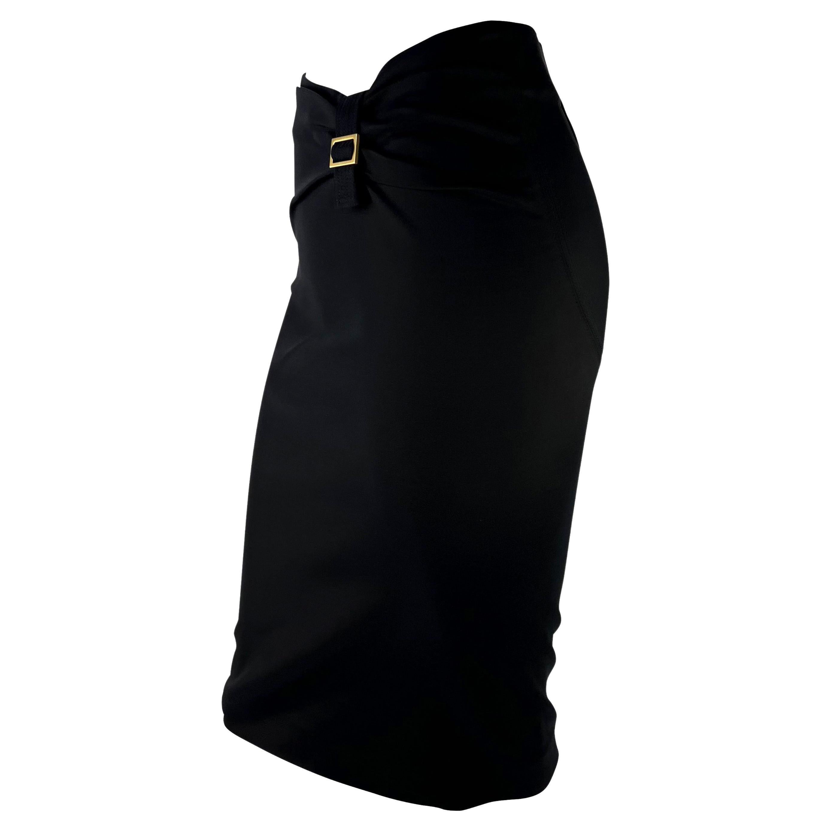 TheRealList presents: a black bodycon Gucci skirt, designed by Tom Ford. From the Fall/Winter 2003 collection, this form-fitting skirt features panels that tactfully enhance the female form. The skirt is made complete with a square gold buckle at