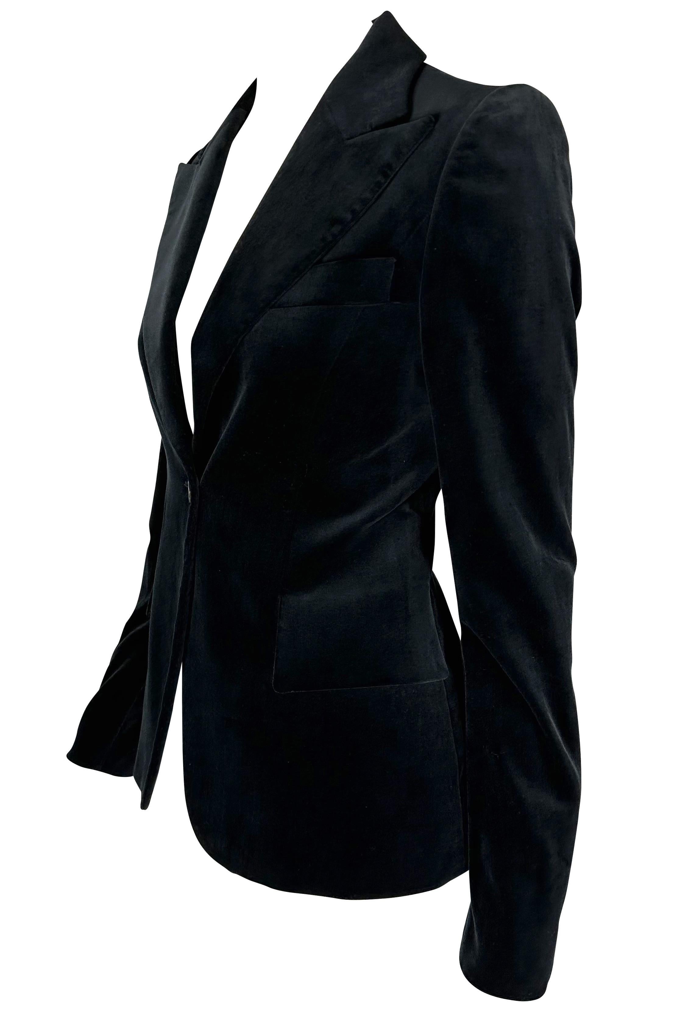 Présentation d'un magnifique blazer noir en velours Gucci, dessiné par Tom Ford. Issue de la collection Automne/Hiver 2003, cette fabuleuse veste en velours se ferme par un seul bouton sur le devant et constitue le complément chic idéal de toute