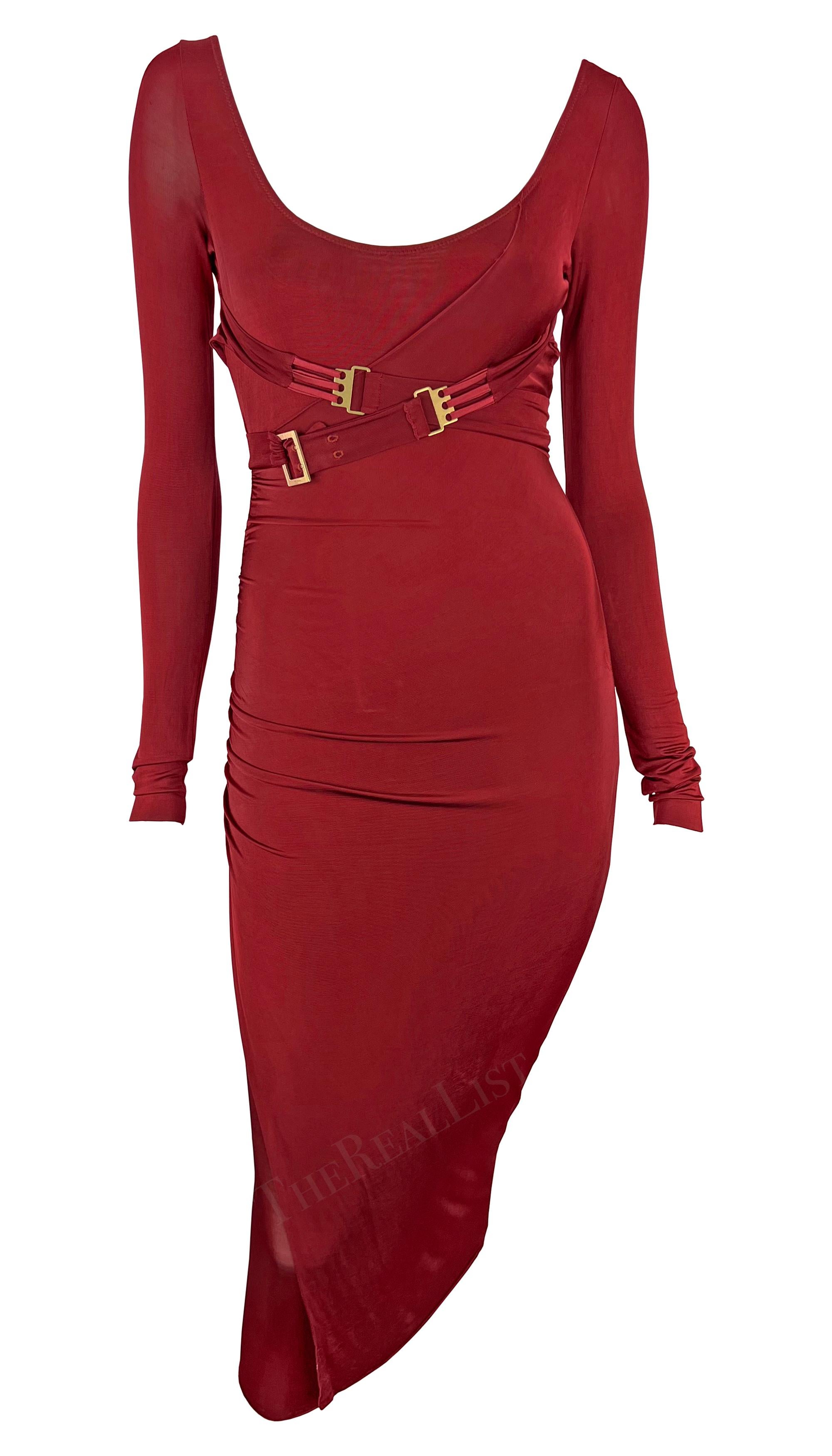 Presenting a fabulous red Gucci body con dress, designed by Tom Ford. From the Fall/Winter 2003 collection, this dress features long sleeves, a knee-length hem, and a low scoop neckline. Made complete with belt buckles that can be wrapped around the