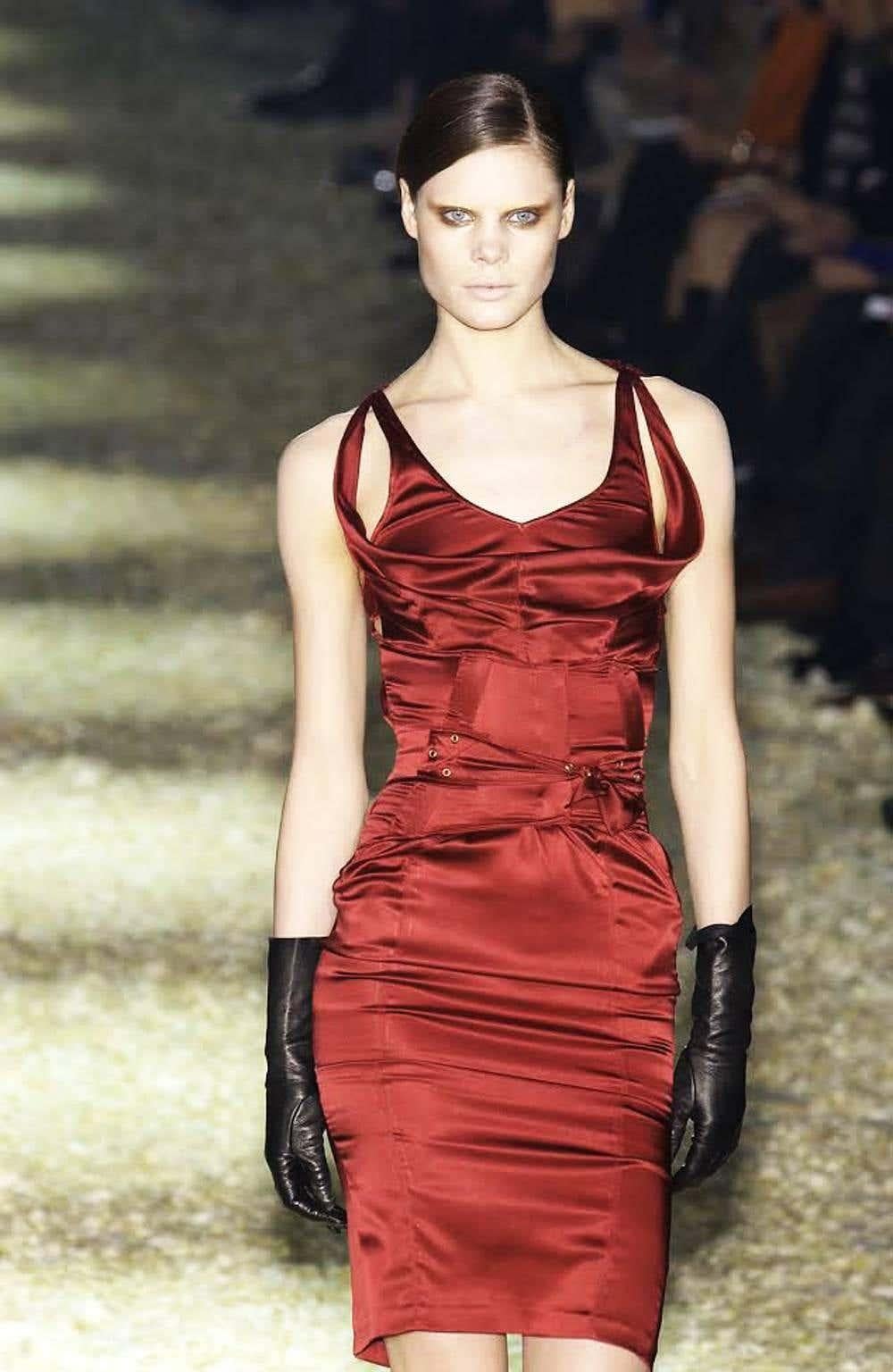 Presenting a stunning ruby red silk satin corset Gucci dress, designed by Tom Ford. From the Fall/Winter 2003 collection, this dress debuted as look number 32 on the season's runway modeled by Adina Fohlin. Constructed entirely of a luxurious satin