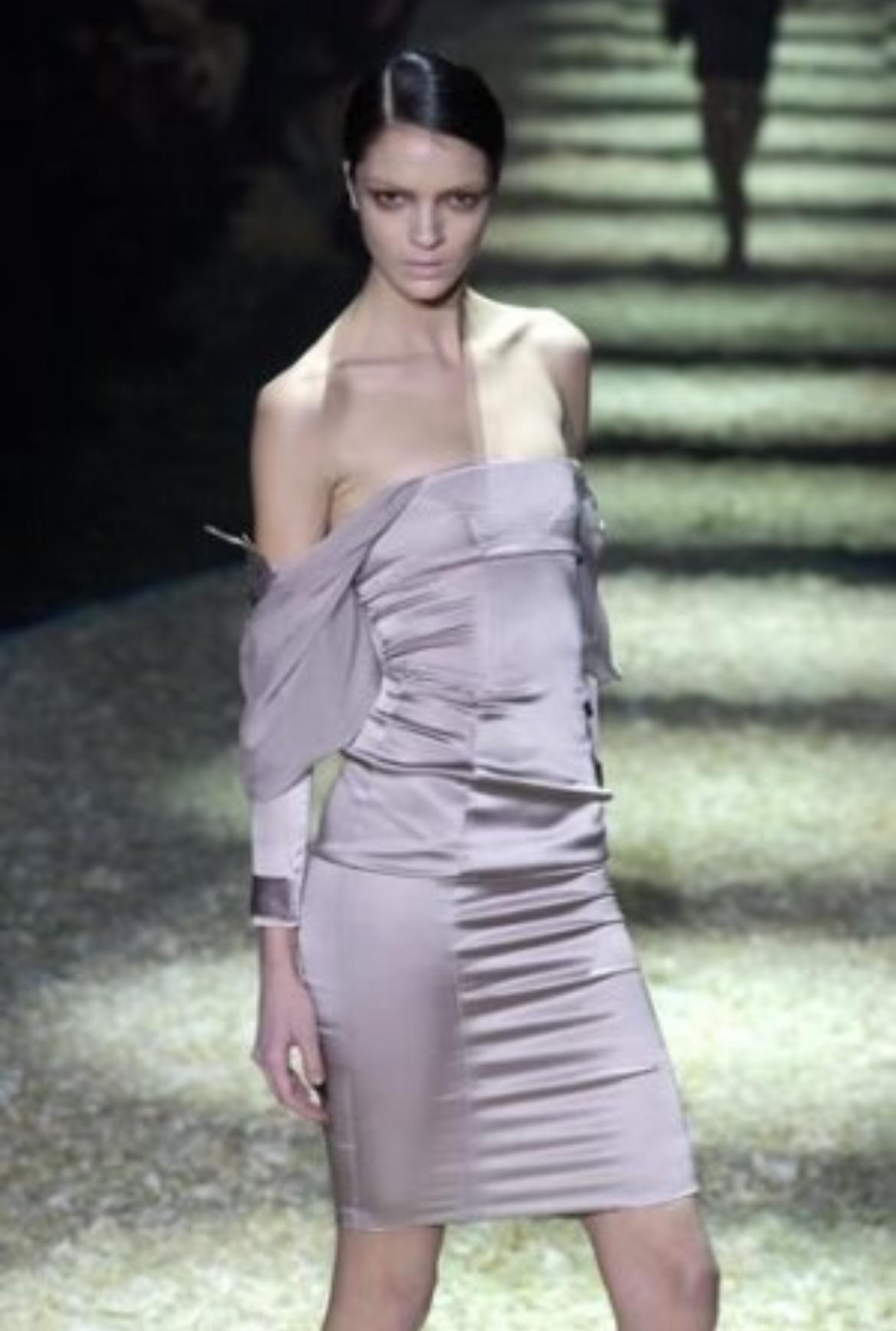 Présentation d'une robe Gucci chic en satin rose poussiéreux, dessinée par Tom Ford. Issue de la collection automne-hiver 2003, cette robe a fait ses débuts sur le podium de la saison en tant que look 28, portée par Mariacarla Boscono. Cette