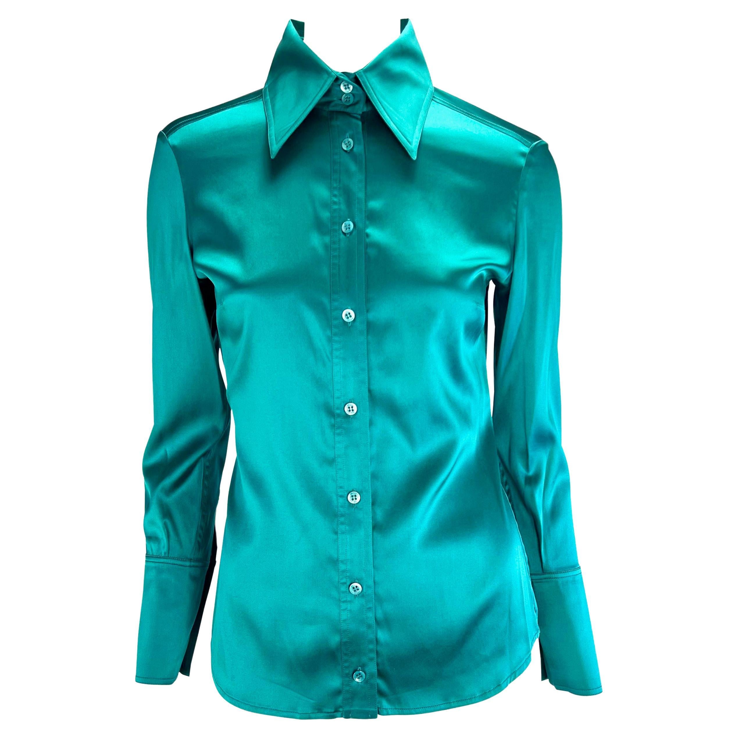 Presenting a collared button up teal silk Gucci top, designed by Tom Ford. The oversized collar and cuffs give the visual illusion of a more petite frame. Words and pictures cannot depict how amazing the fabric on this shirt is in person.