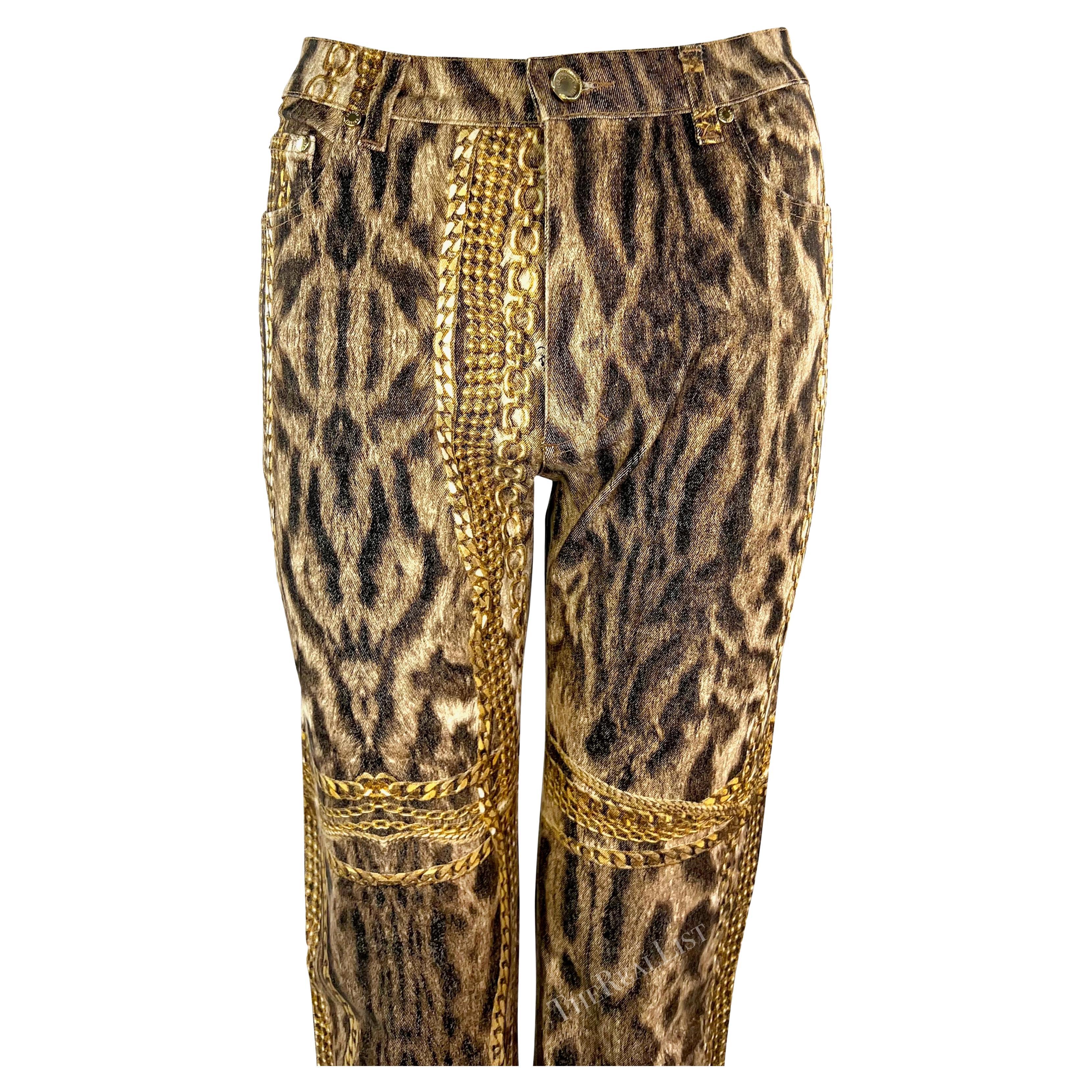 Presenting a pair of cheetah print denim Roberto Cavalli pants. From the Fall/Winter 2003 collection, these fabulous pants feature a cheetah print with gold chains throughout. The perfect encapsulation of early 2000s Roberto Cavalli, these cheetah