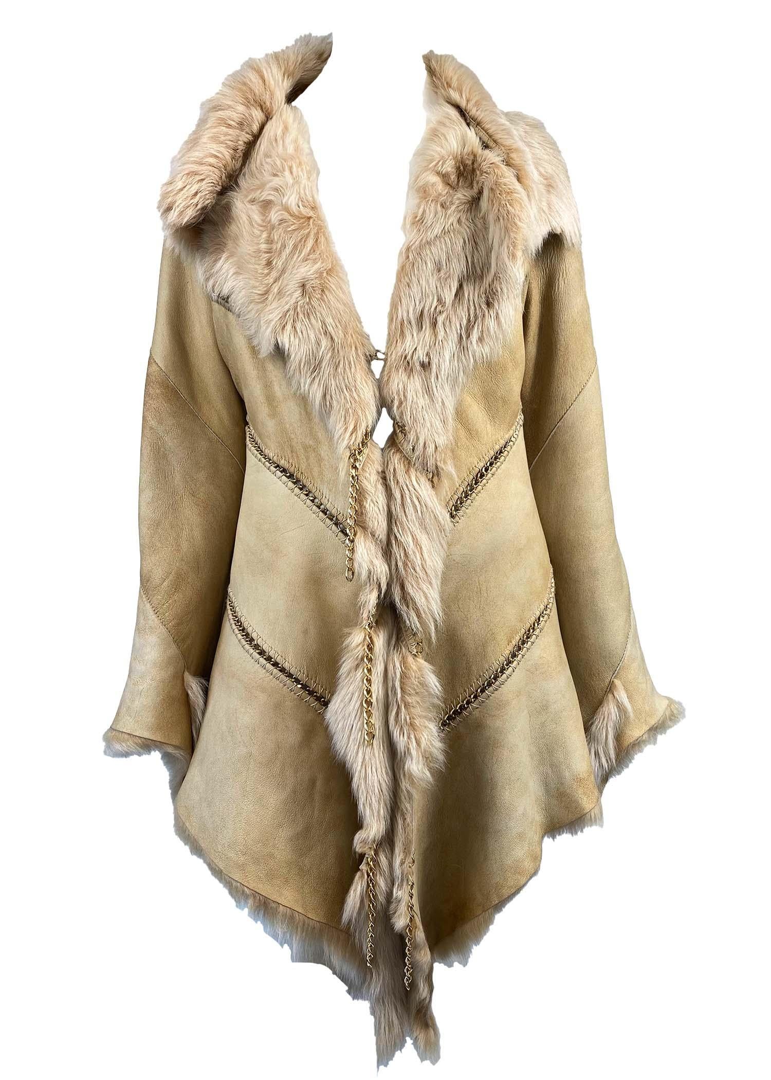 Presenting a chain detail suede and shearling coat by Roberto Cavalli. This piece was produced for Cavalli's F/W 2003 collection and features gold metal chains between panels of thick suede shearling. The chains continue to the exterior of the coat,