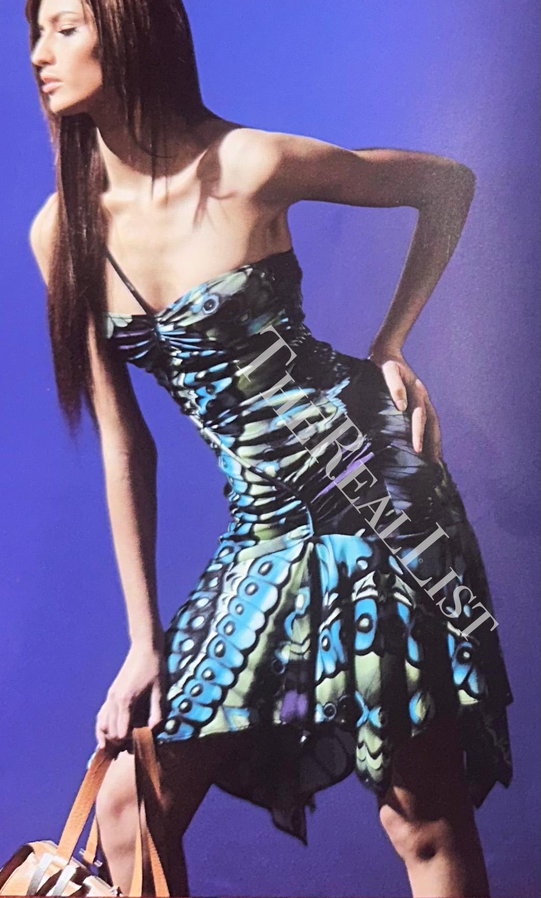 Nous vous présentons une superbe mini robe bleue à imprimé papillon Versace, créée par Donatella Versace. Issue de la collection Automne/Hiver 2003, cette robe à l'imprimé vibrant d'ailes de papillon crée un attrait visuel audacieux, rehaussé par