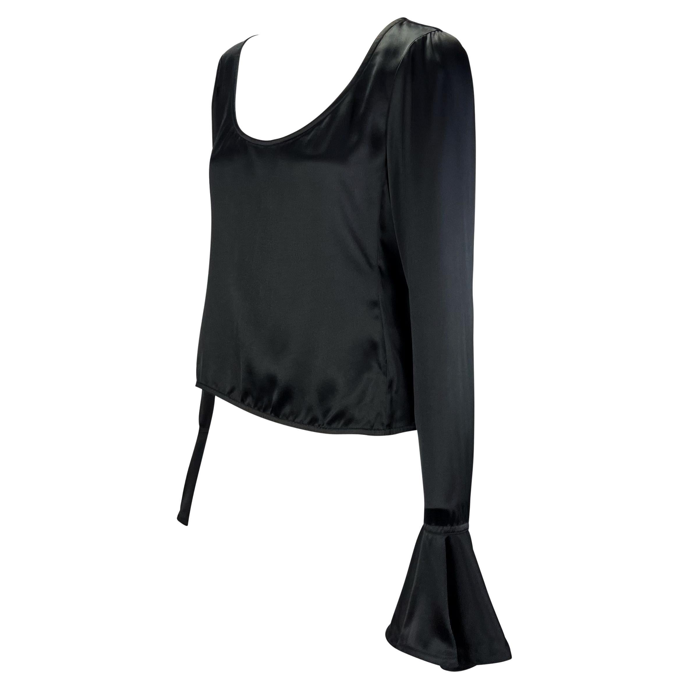Presenting a luxurious black silk satin blouse designed by Tom Ford for Yves Saint Laurent Rive Gauche's Fall/Winter 2003 collection. A large scoop neckline and fabulously oversized bell cuffs make this Y2K dream a true knock-out. Check out our