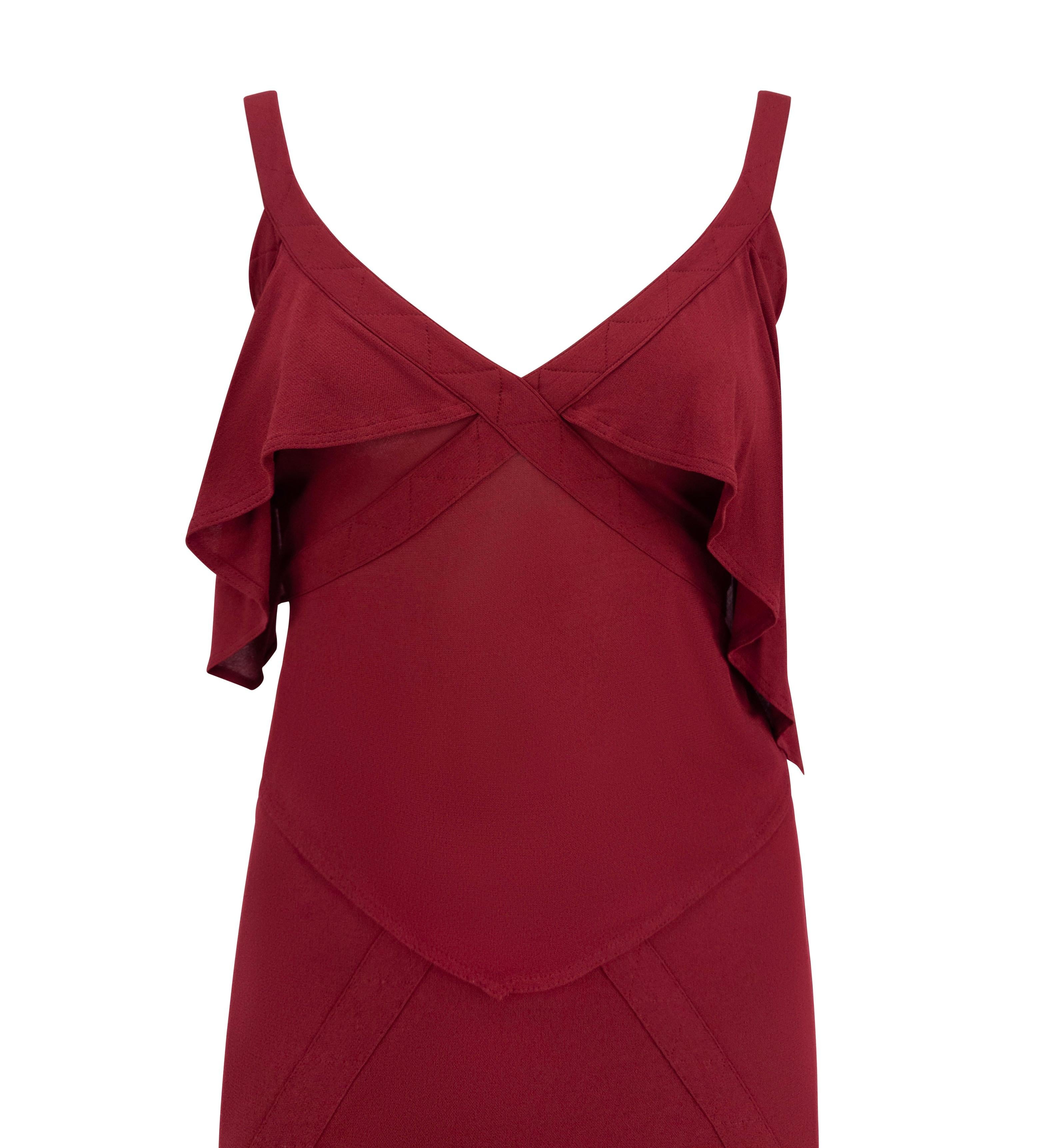 De la colección Otoño/Invierno 2003 de Yves Saint Laurent bajo la dirección de Tom Ford, este conjunto de dos piezas incluye una camiseta de tirantes elástica de color rojo transparente con suaves detalles de volantes y una falda midi asimétrica a