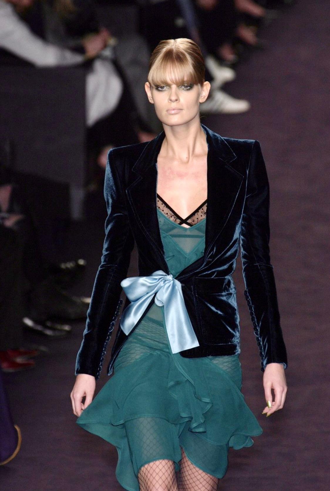 Ti presentiamo un abito con gonna in velluto verde intenso disegnato da Tom Ford for Yves Saint Laurent Rive Gauche per la collezione Autunno/Inverno 2003. La giacca blazer ha debuttato sul look numero 1 di Julia Stegner. Indossato da Demi Moore