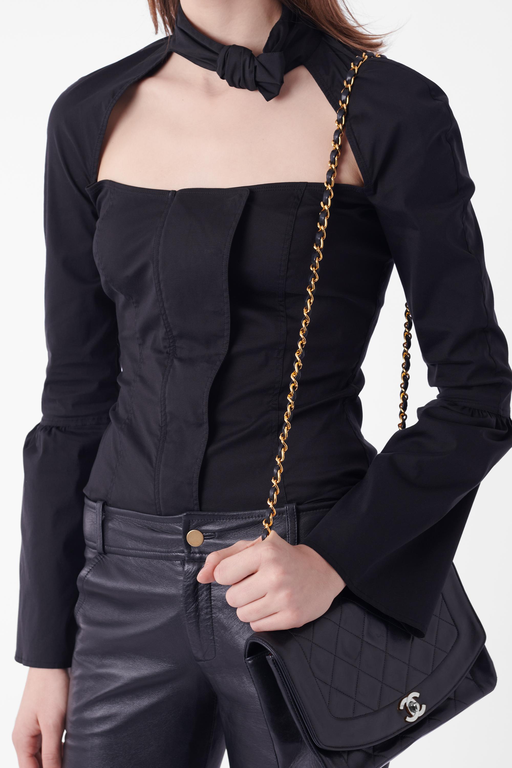 Nous avons le plaisir de vous présenter cette blouse à découpes carrées noire Gucci by Tom Ford Fall Winter 2004. Col montant à détails de boucles, poitrine ouverte et découpée, fermeture à glissière et bouton sur le devant, manches longues avec
