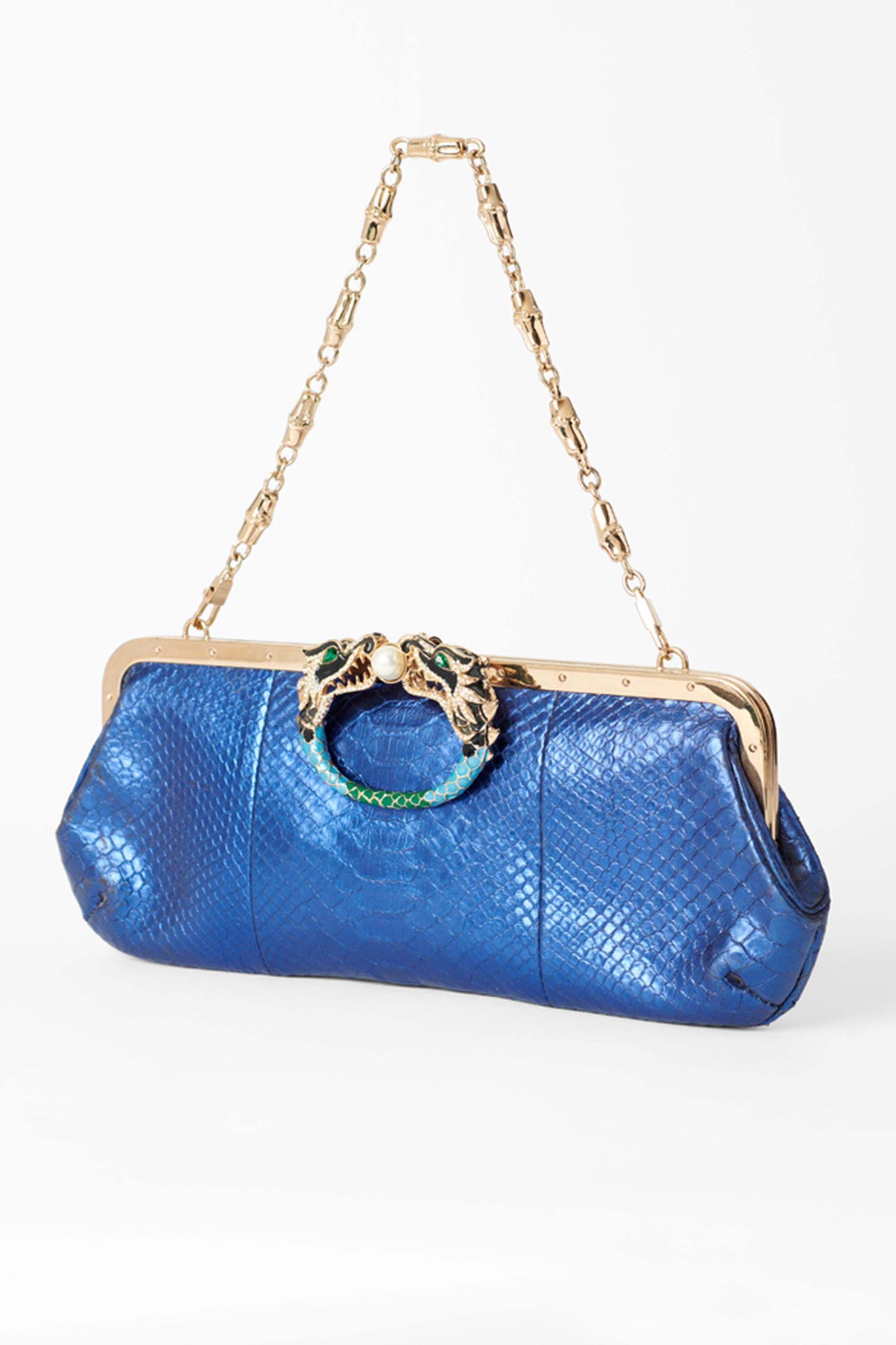 Gucci by Tom Ford Fall Winter 2004 blue clutch. Features embellished dragon centre with pearl centre, blue iridescent snake body, gold detachable shoulder chain and inside back pocket. In great vintage condition.

Brand: Gucci
Color: Blue
Year /