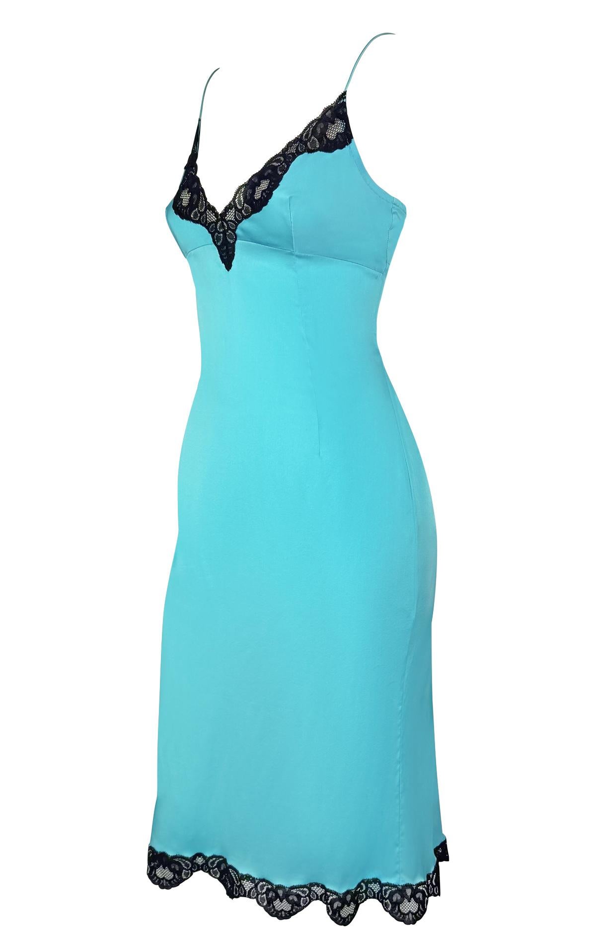 From Dolce & Gabbana’s Fall/Winter 2004 collection, this light blue satin slip dress features a V-neckline and delicate black lace trim along the neckline and hem. The figure-skimming silhouette is finished with thin spaghetti straps, reflecting the