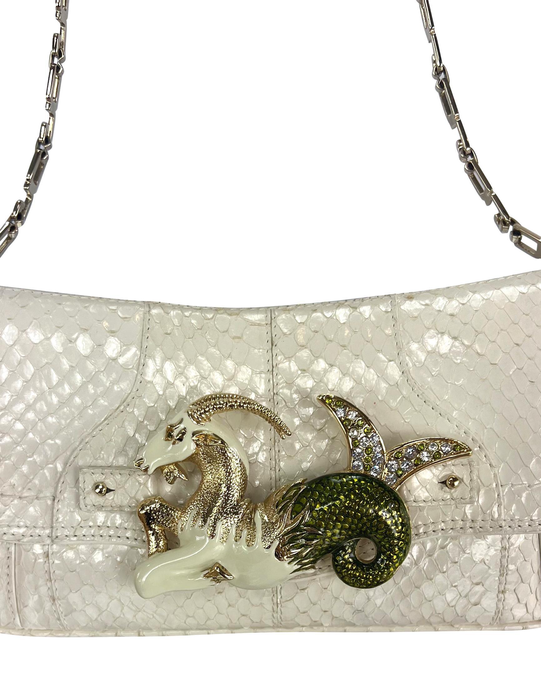 Collectional présente un sac à bandoulière horoscope Dolce & Gabbana en peau de serpent blanc cassé de la collection automne/hiver 2004. Ce sac à rabat est réalisé en peau de python noir et comporte une boucle en émail et strass représentant le