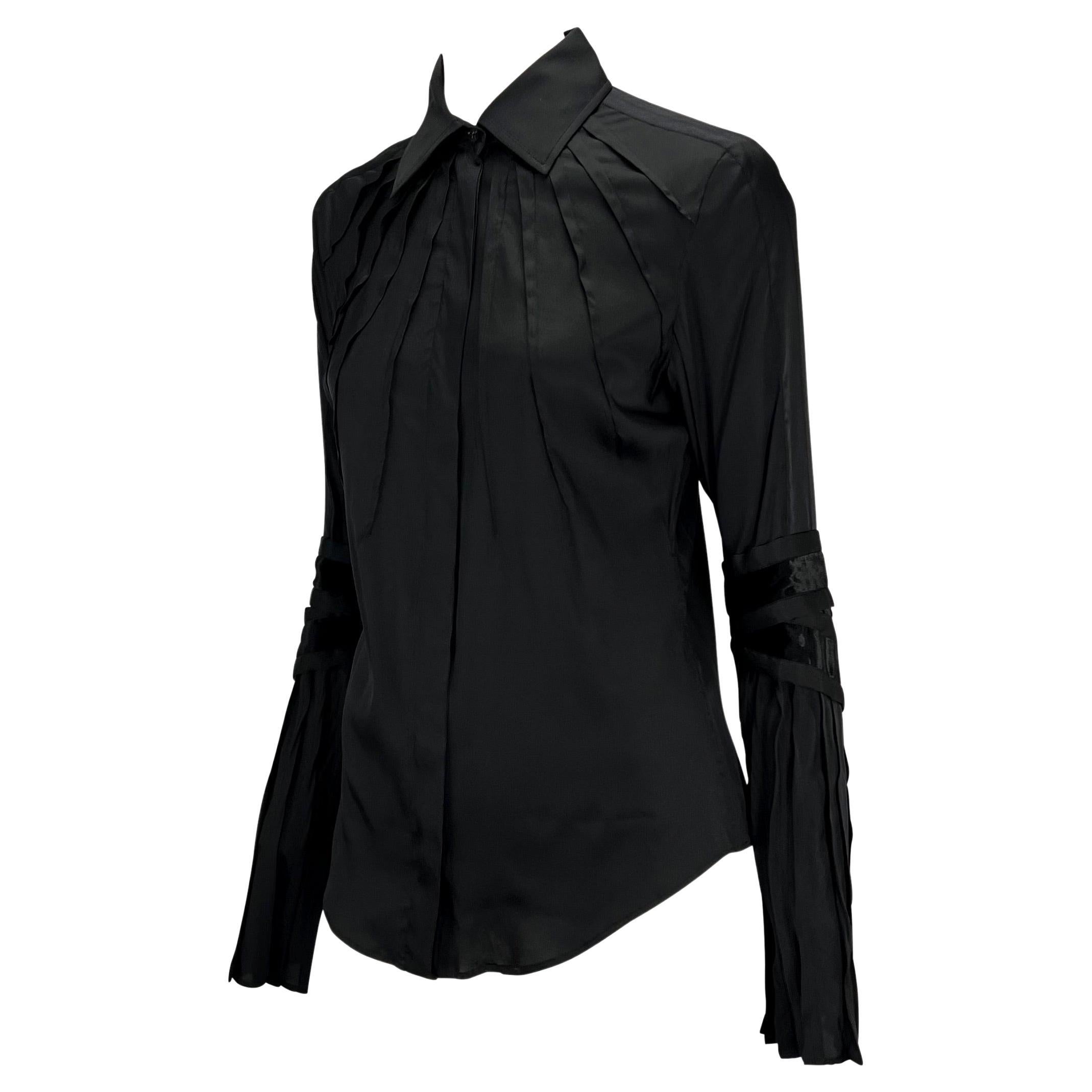 Presenta una camicia di seta nera button-up di Gucci, disegnata da Tom Ford. Questo incredibile capo della collezione Autunno/Inverno 2004 è realizzato in misto seta e spandex e presenta pieghe che sporgono dalla scollatura e dal gomito. La blusa è