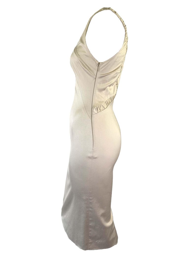TheRealList presents: a stunning creme color sleeveless Gucci dress, designed by Tom Ford. This new with tags dress is from the Fall/Winter 2004 collection and features a peekaboo opening at the bust with ruched accents and skirt slit at the back.