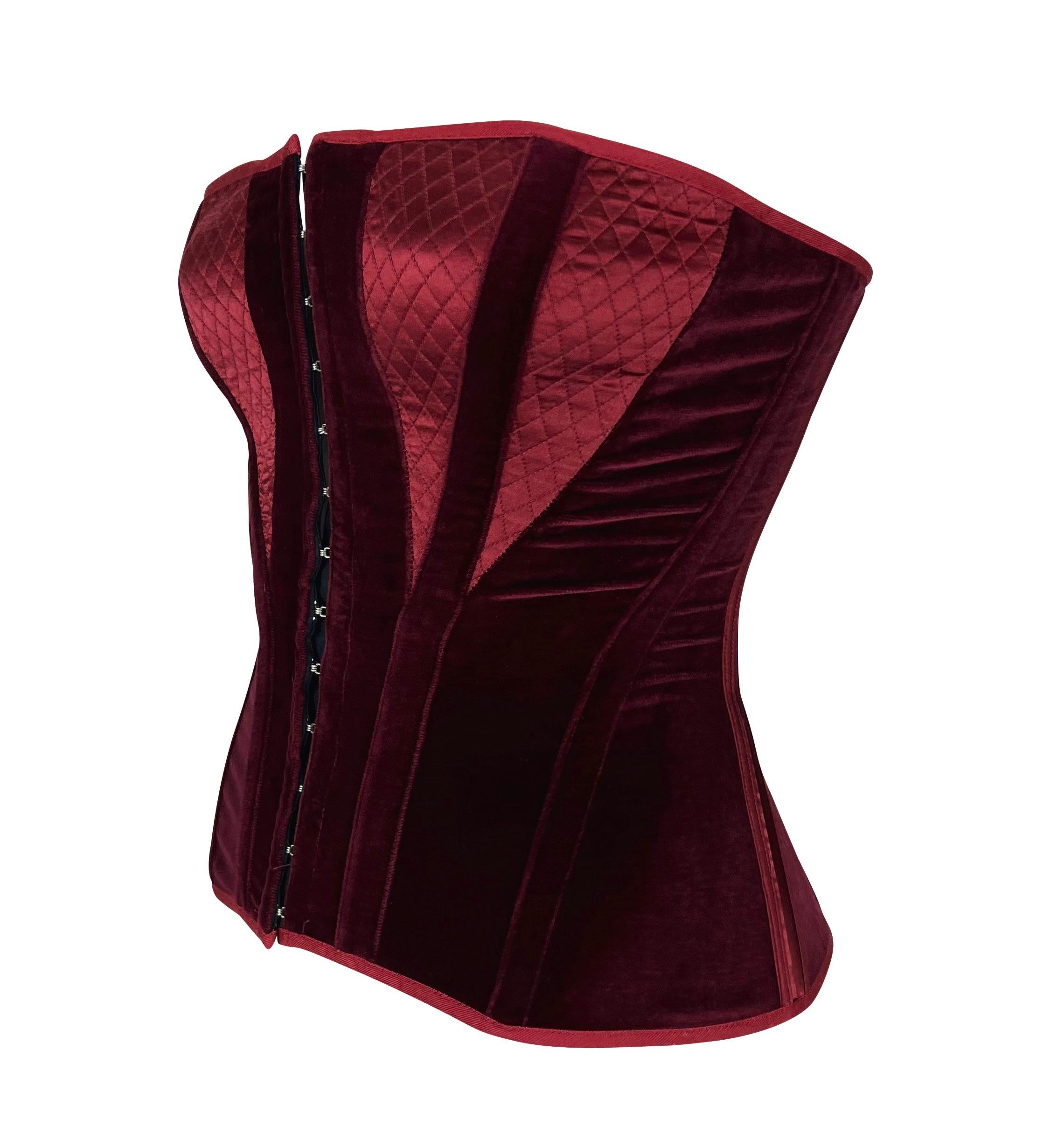 Presenting a gorgeous burgundy velvet Roberto Cavalli corset. From the Fall/Winter 2004 collection, this stunning strapless corset features a silver-tone hook and eye closures at the front, a lace closure at the back, and a boning throughout.