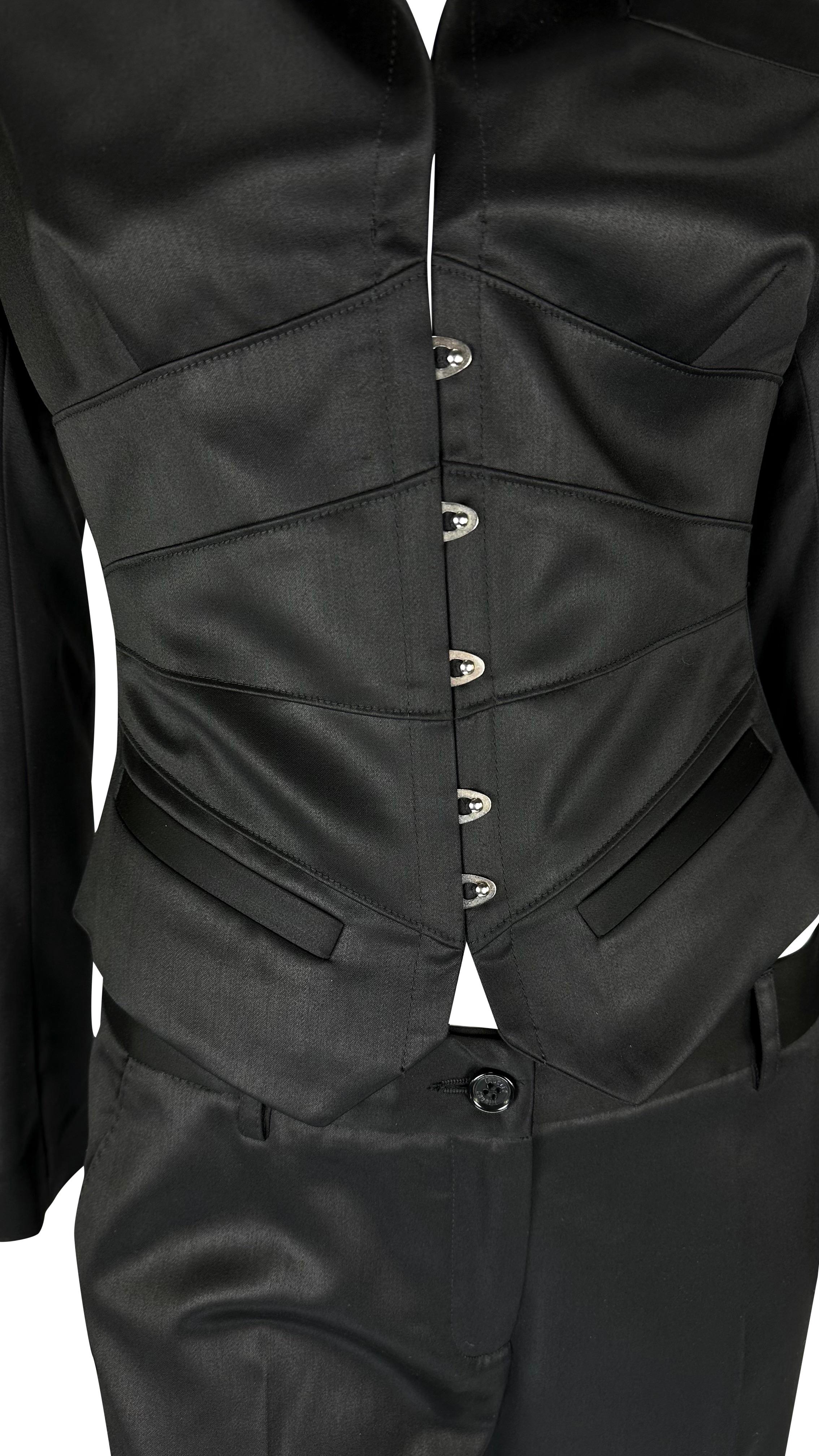 Presenting an incredible black corset Roberto Cavalli pantsuit. From the Fall/Winter 2004 collection, this suit is comprised of a black satiny corsetted blazer and matching wide-leg pants. The jacket in this set features metal boning used as a