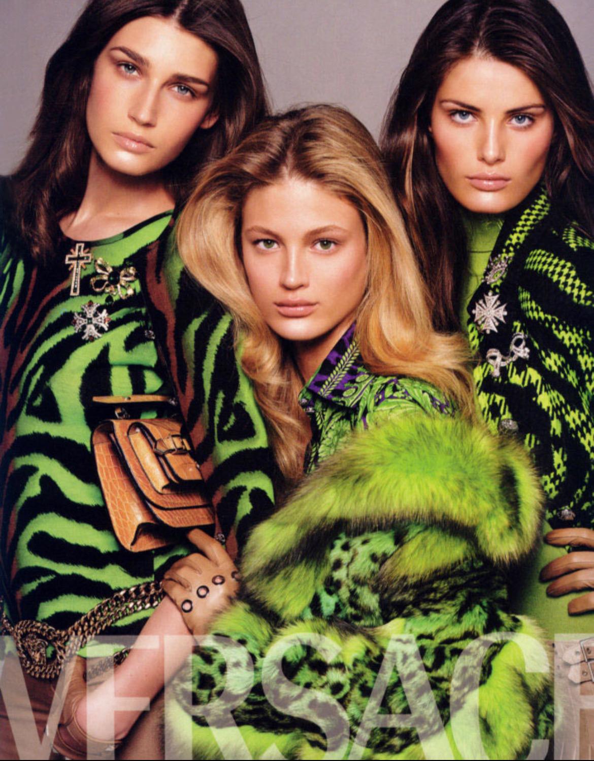 Wir präsentieren ein lilafarbenes Kleid mit Tigerprint von Versace, entworfen von Donatella Versace. In der Herbst/Winter-Kollektion 2004 wurde derselbe Print in Gelb/Orange bei den Looks 8 und 11 gezeigt. Dieses wunderschöne dunkelviolette Kleid