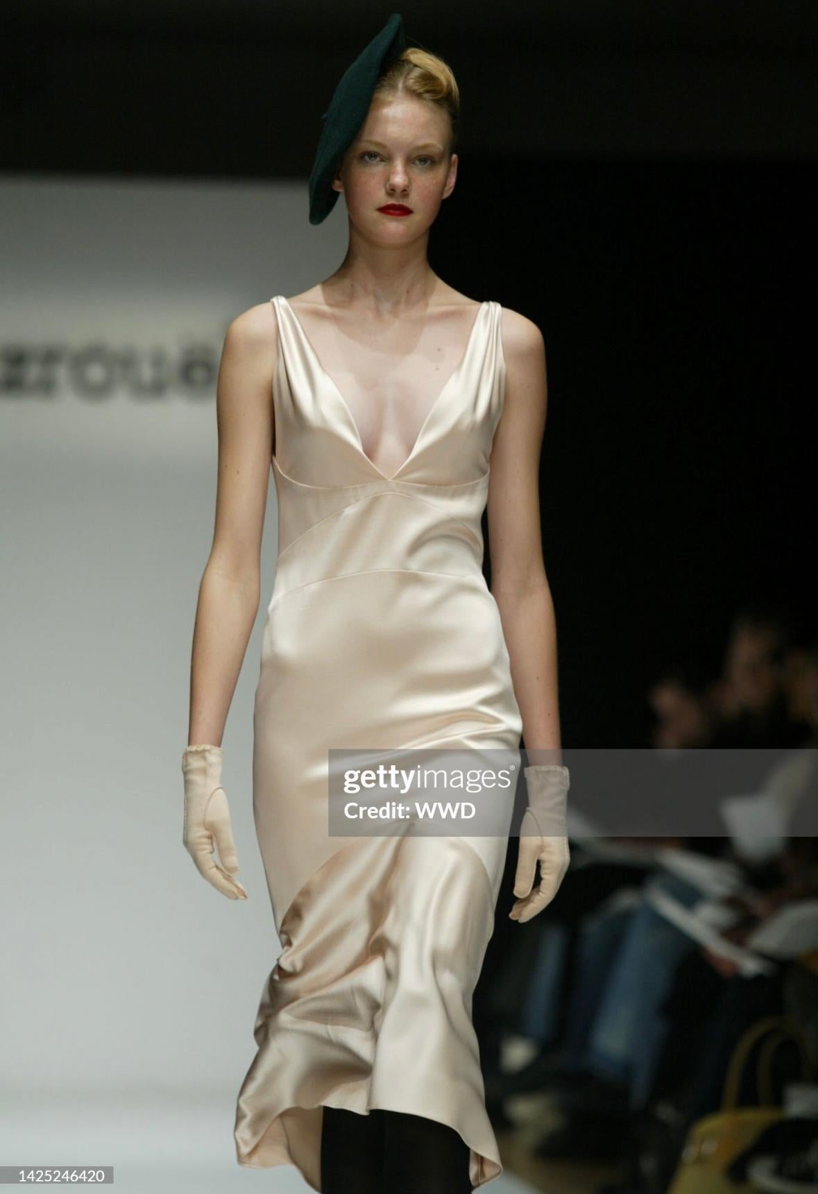 Voici une robe en satin rose pâle, longueur genou, de Yigal Azrouël, de la collection automne/hiver 2004. Cette robe sans manches d'un rose tendre a fait ses débuts sur le podium de Bryant Park lors de la Semaine de la mode de New York. Ce classique