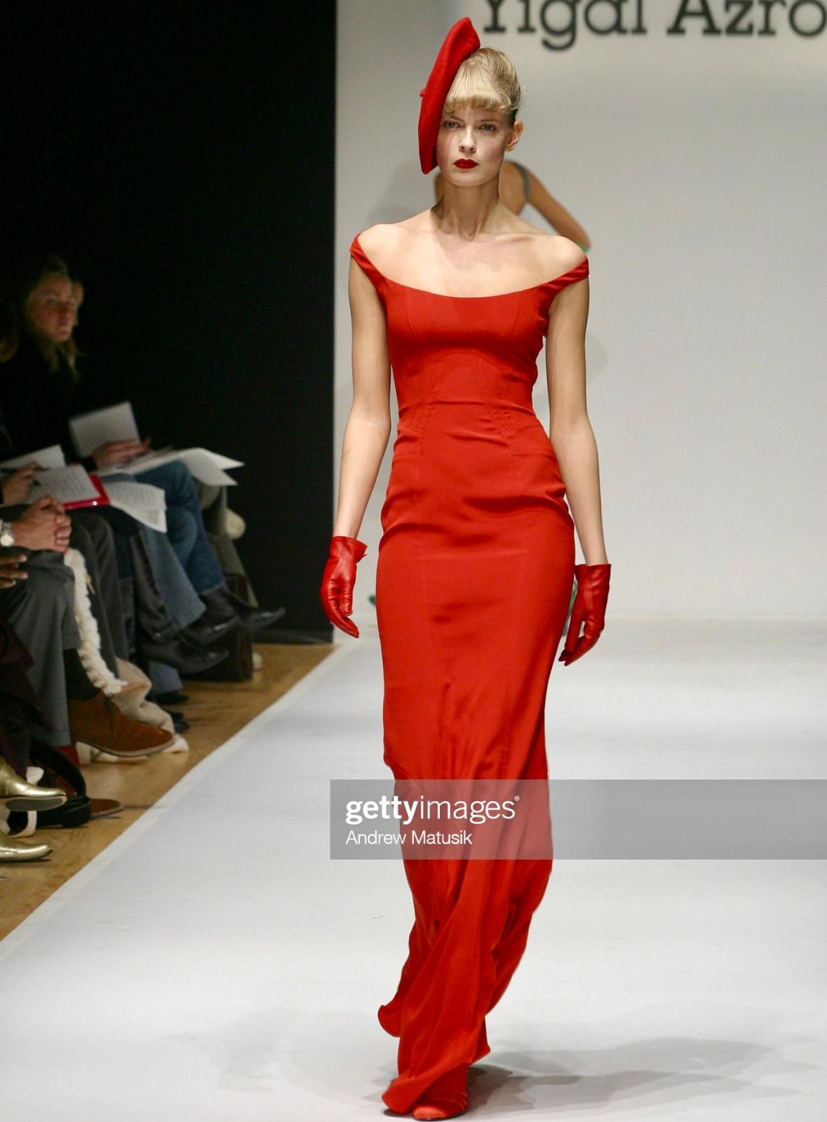 Presenting a stunning bright red Yigal Azrouël bodycon gown. From the Fall/Winter 2004 collection, this dress debuted on the season's runway in NYC. This chic dress is constructed entirely of a luxurious silk satin and features a wide scoop