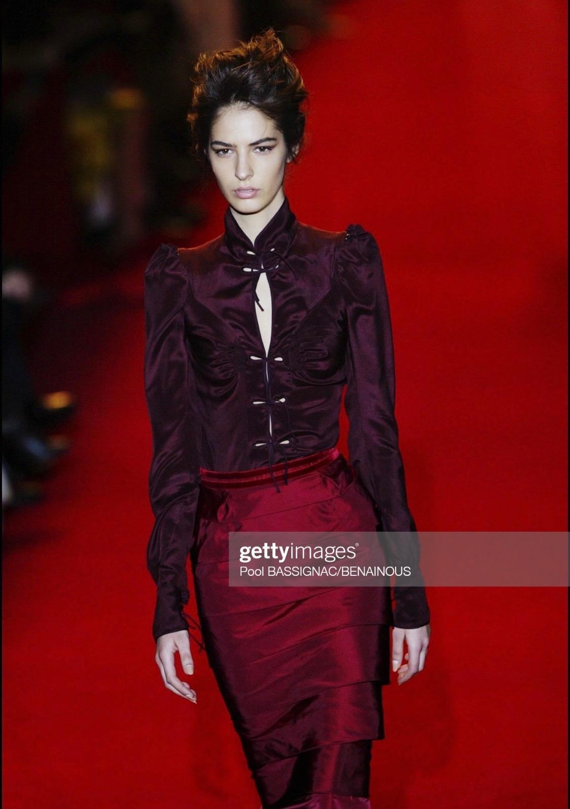 Presenting a gorgeous burgundy satin chinoiserie top, designed by Tom Ford for Yves Saint Laurent Rive Gauche. This gorgeous shirt was masterfully designed by Tom Ford who reintroduced exaggerated pagoda shoulders to create the appearance of a