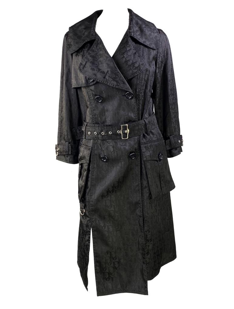 Presenting a Diorissimo monogram jacquard trench coat designed by John Galliano for Christian Dior's Fall/Winter 2005 collection. This piece is one of Galliano's more subtle Diorissimo designs in chic black with silver-toned hardware. Add this piece