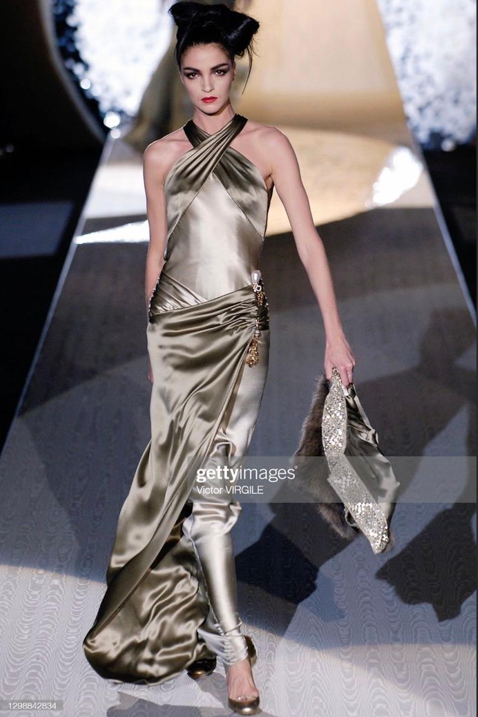 Elle présente une incroyable robe de haute couture Valentino en soie vert olive/sage. Issue de la collection automne-hiver 2005, cette robe en satin lustré a fait ses débuts sur le défilé de la saison en tant que look 26, porté par Mariacarla
