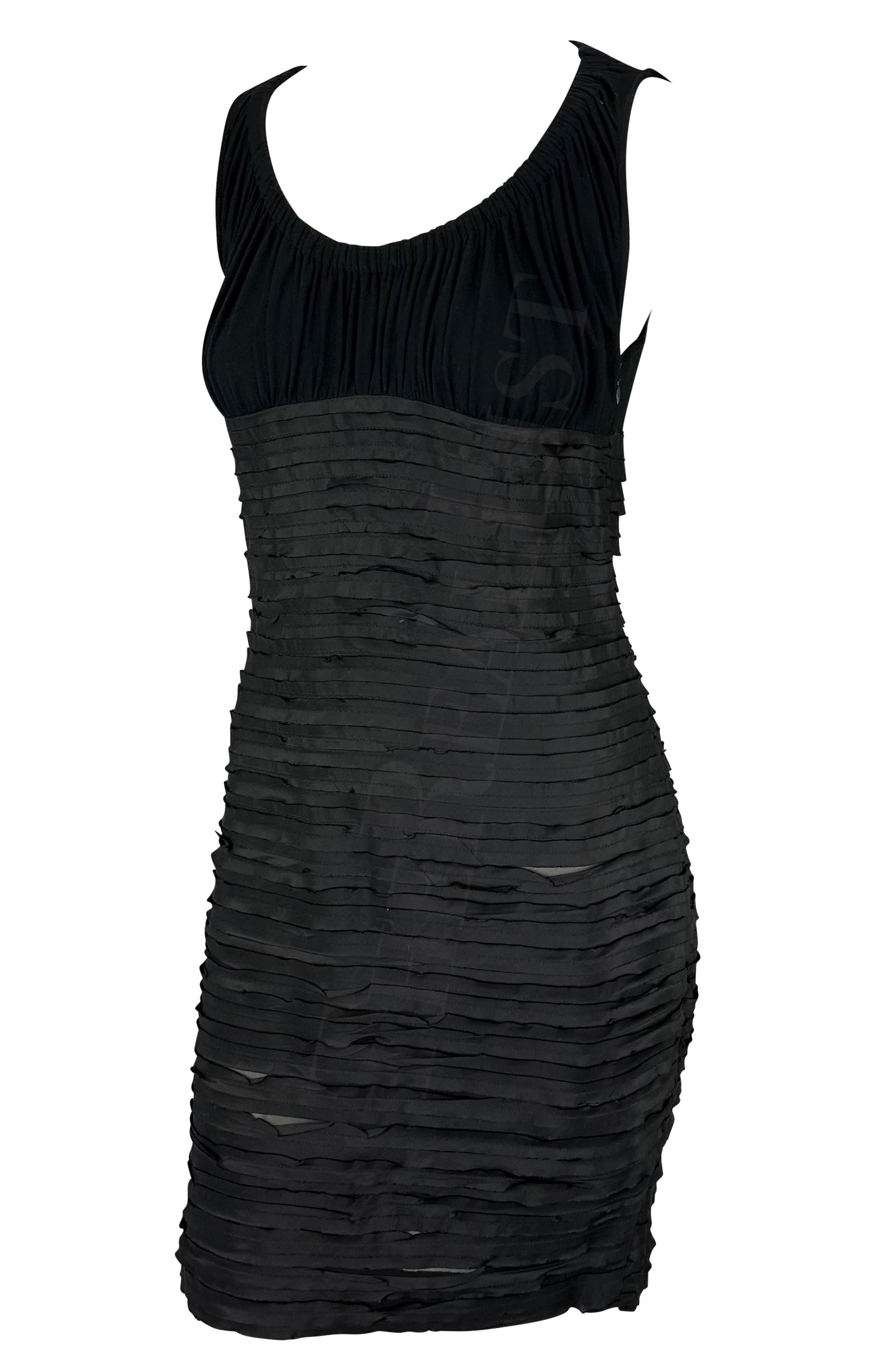 Ich präsentiere ein schickes schwarzes Minikleid von Versace, entworfen von Donatella Versace. Dieses Kleid aus der Herbst/Winter-Kollektion 2005 hat einen weiten Rundhalsausschnitt, einen verdeckten Reißverschluss und ein Band, das um Taille und