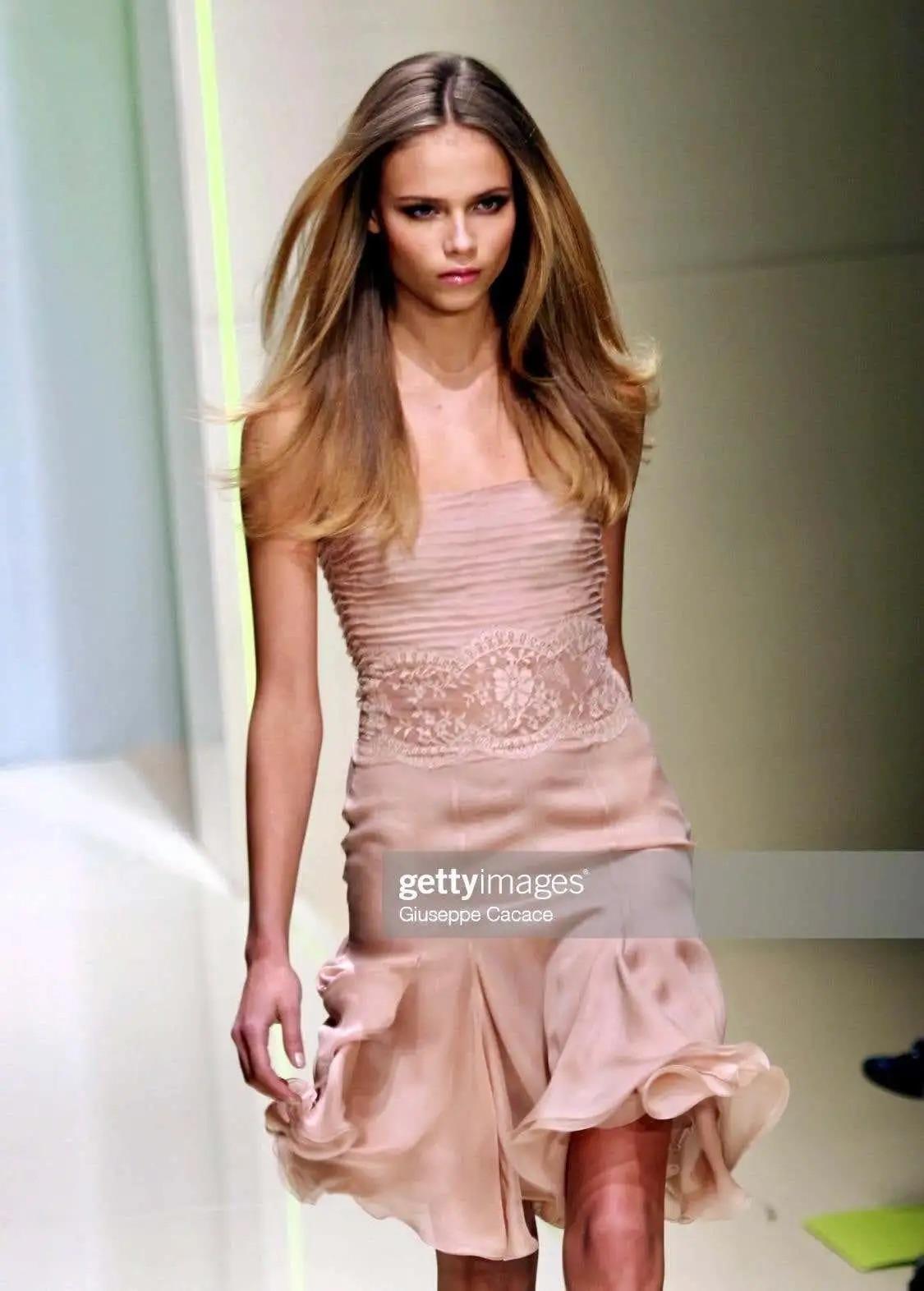 Presenting a black lace Versace Medusa medallion mini dress, designed by Donatella Versace. From the Fall/Winter 2005 collection, the beige version of this dress debuted on the runway as look number 36 modeled by Natasha Poly. Frayed sheer silk at