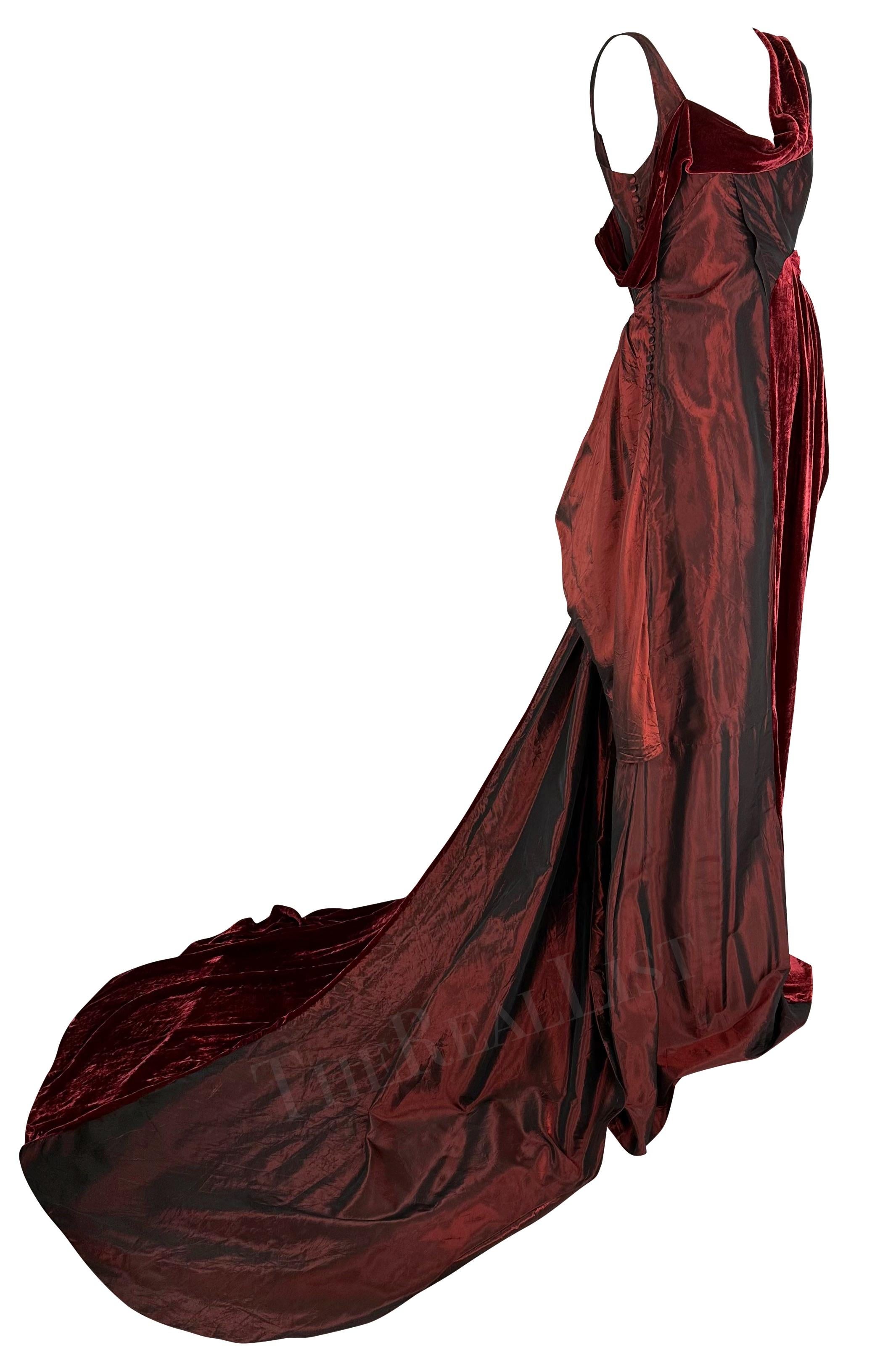 Presenting an incredible burgundy John Galliano gown. From the Fall/Winter 2006 collection, this stunning backless gown is constructed of silk and velvet panels, both in a rich semi-iridescent shade of burgundy. The gown is accented with Galliano's