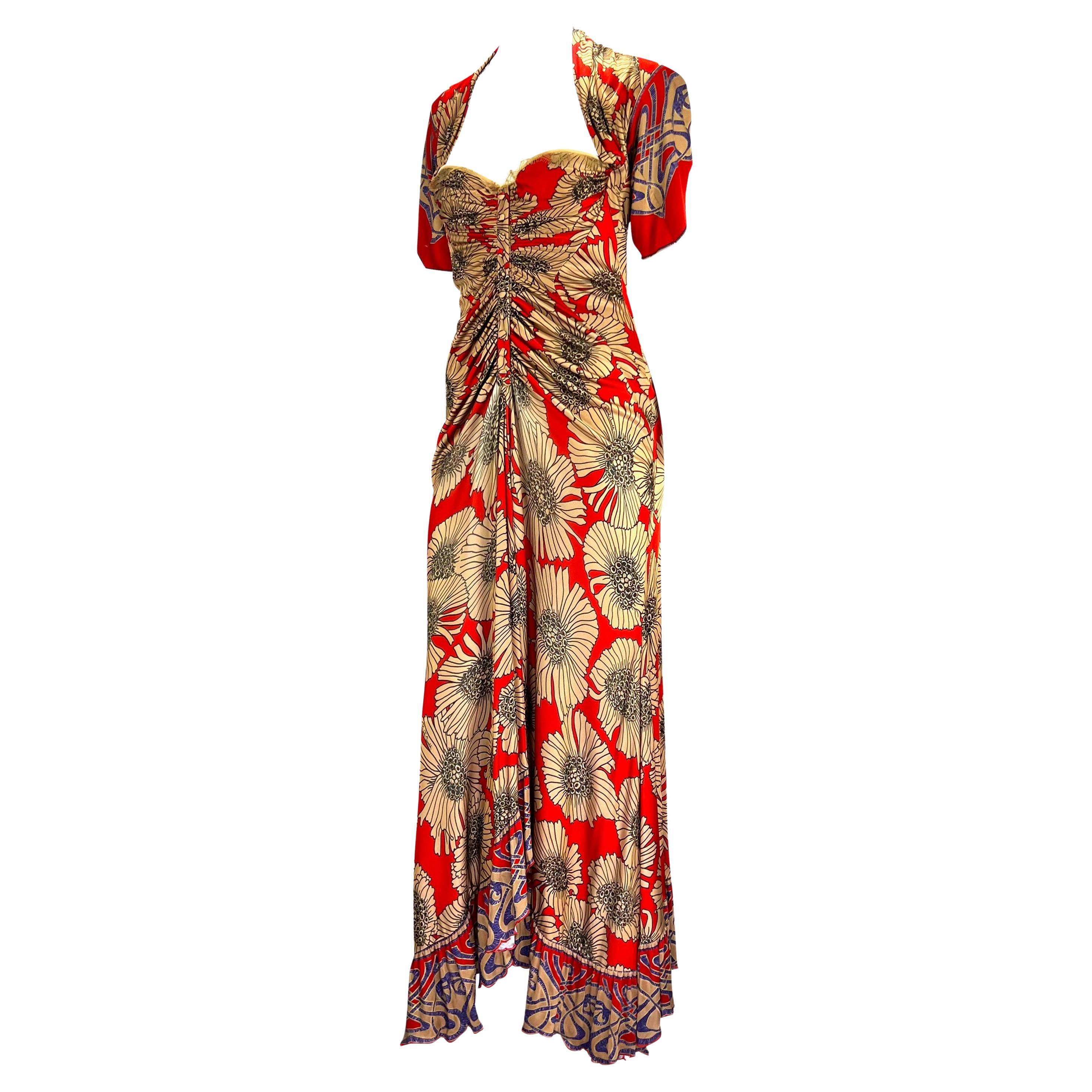 TheRealList presents: a red floral Roberto Cavalli bustier maxi dress. From the Fall/Winter 2006 collection, this dress features quarter-length sleeves with slits at the back, a sweetheart neckline with a faux button-down closure, and pleating at