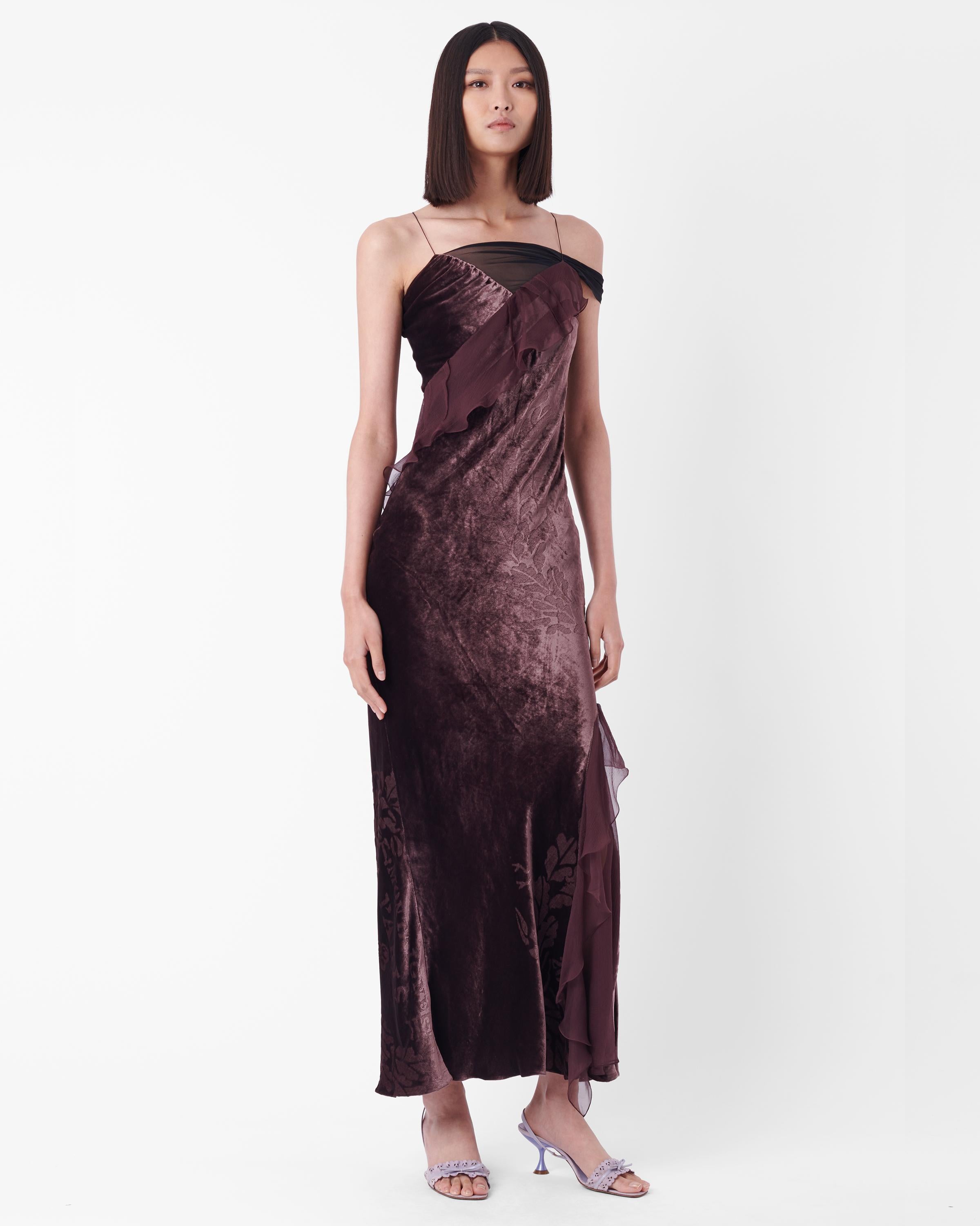 Robe Christian Dior automne-hiver 2006, telle que vue sur le podium. Elle est dotée de bretelles fines, d'un empiècement en maille sur une face, de volants asymétriques le long de la robe, d'un corps en velours imprimé et d'une fermeture à bouton