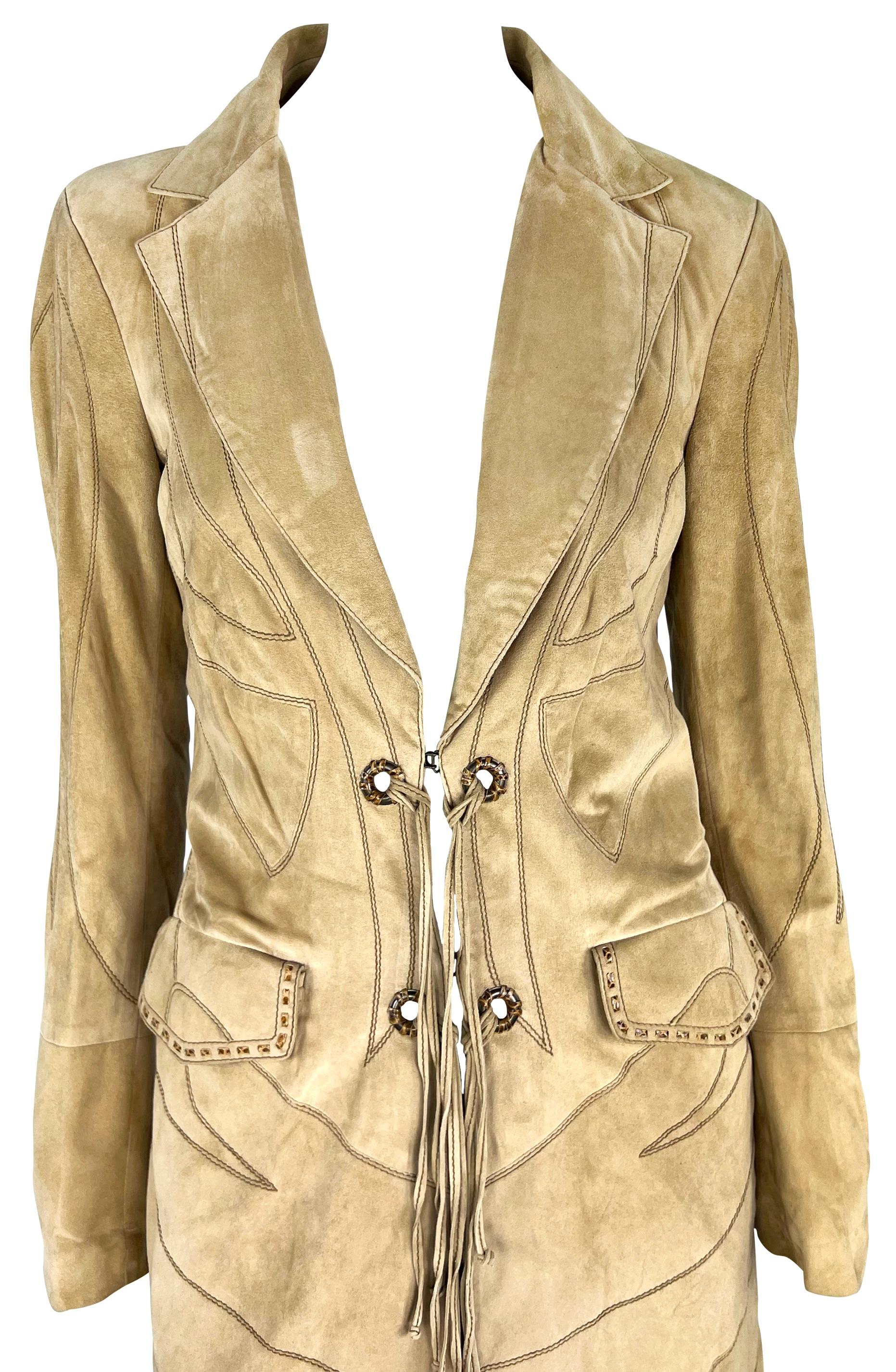 From the Fall/Winter 2007 Roberto Cavalli collection, this American West-inspired coat is constructed entirely of tan suede. The coat is covered in dramatic embroidery and features a fold-over collar, pockets at the hips, snakeskin whipstitch