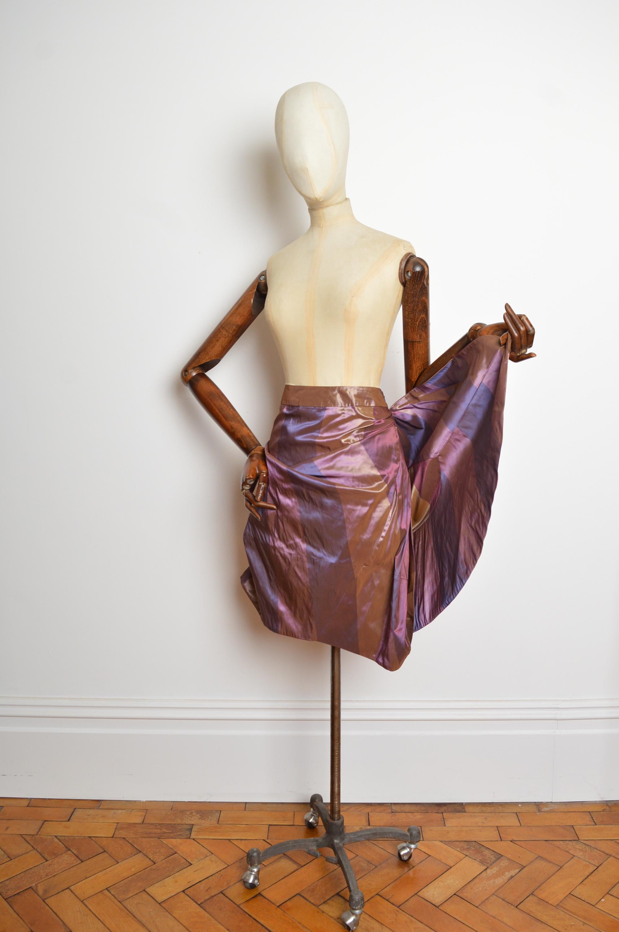 A Beautiful structured Vivienne Westwood skirt from the Fall / Winter 2011 collection, in Shades of Mulberry and iridescent gold two tone taffetta, featuring a draped silhouette and a concealed zip through the side to ensure a beautiful
