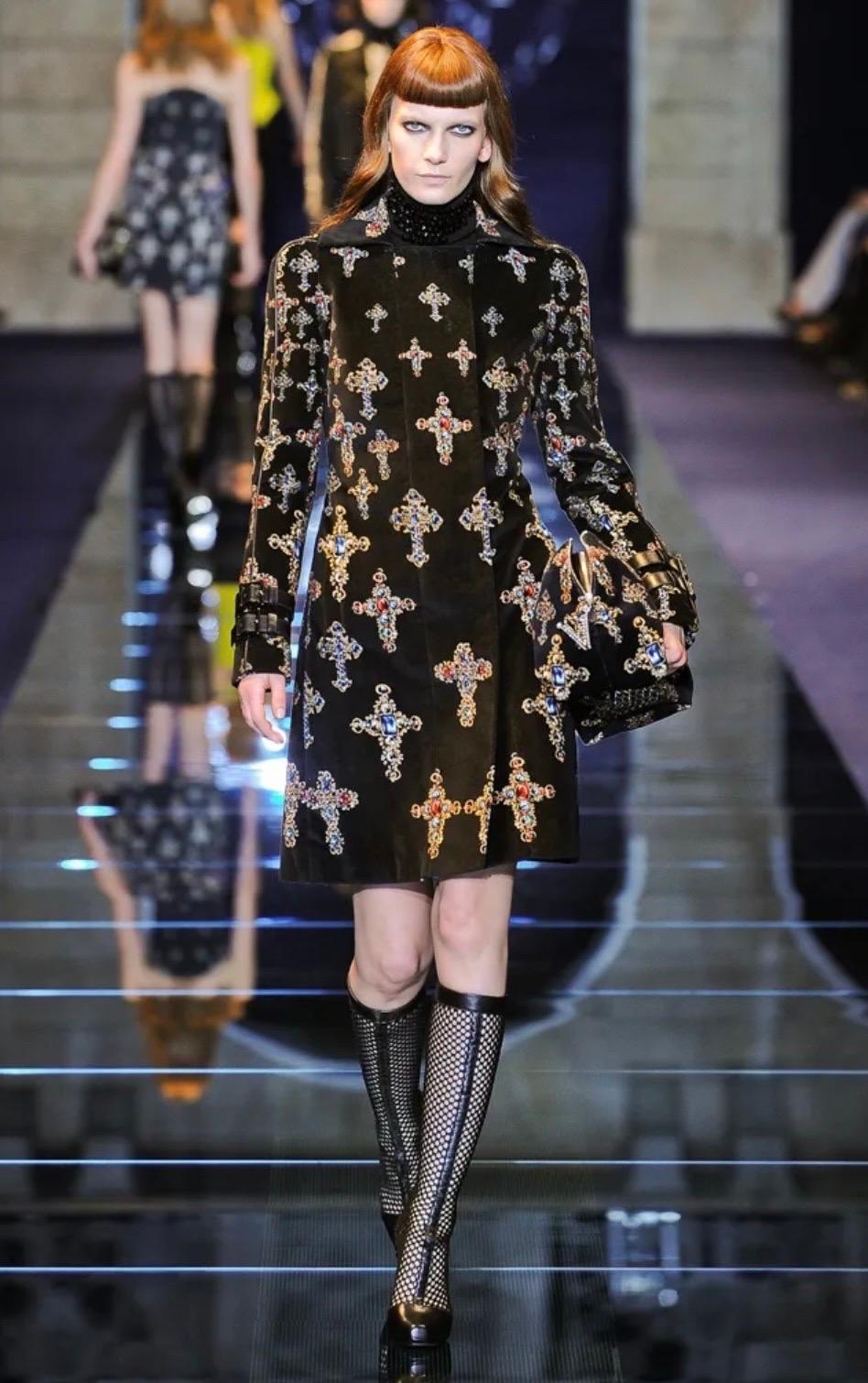 Versace black velvet coat featuring an allover multicolor gothic baroque cross pattern throughout. From the Fall/Winter 2012 collection and as seen on the runway.
Buckle fastening leather tabs at cuffs.
Hidden zipper and snap button closure on the
