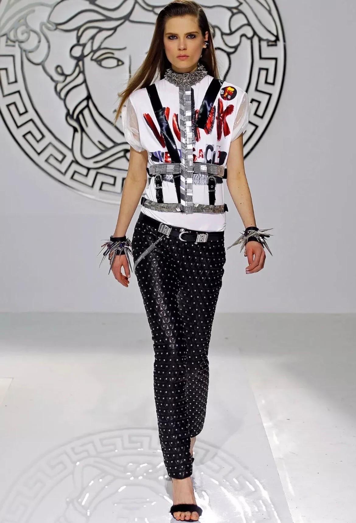 VERSACE
Fall/Winter 2013 Look # 30
This fully embellished t-strap harness from Versace features spike studs and
crystal hardware. 
Double buckle closure.
85% polyamide, 15% elastane with 100% polyurethane face with crystal and metal
tube