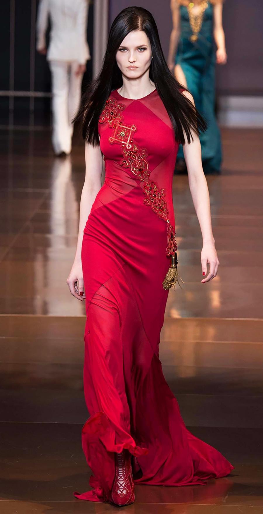VERSACE
La robe portée par Megan Fox
Échantillon actuel du défilé Automne/Hiver 2014 look #49

Cette robe asymétrique en soie est de couleur rouge. 

La robe est accompagnée d'une ceinture embellie. L'écharpe peut être montée ensemble ou