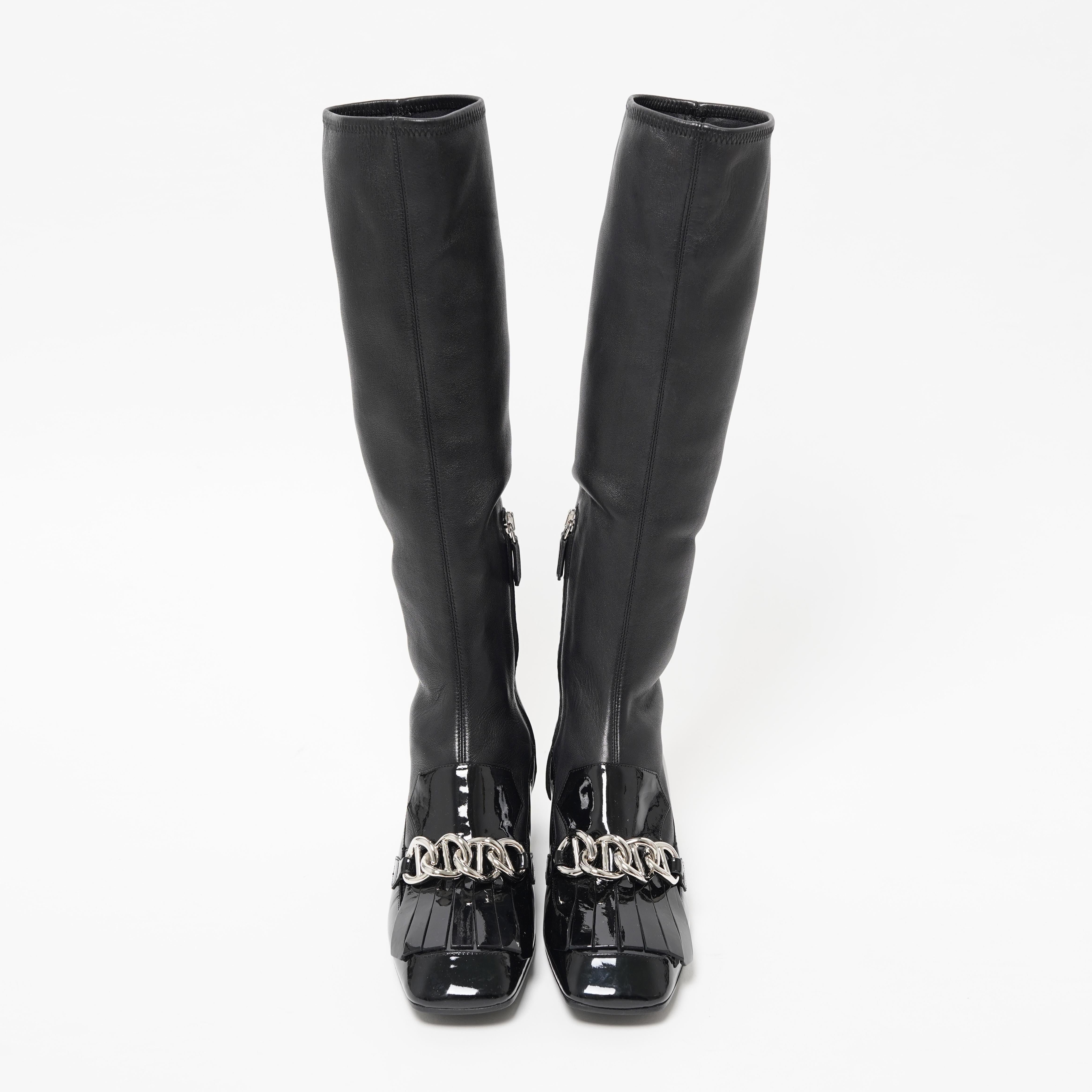Presenting the Prada F/W 2015 black Napa leather embellished sock boots. These striking knee-high boots from Prada’s Fall/Winter 2015 collection blend bold sophistication with contemporary edge. Expertly crafted from supple black Napa leather, they