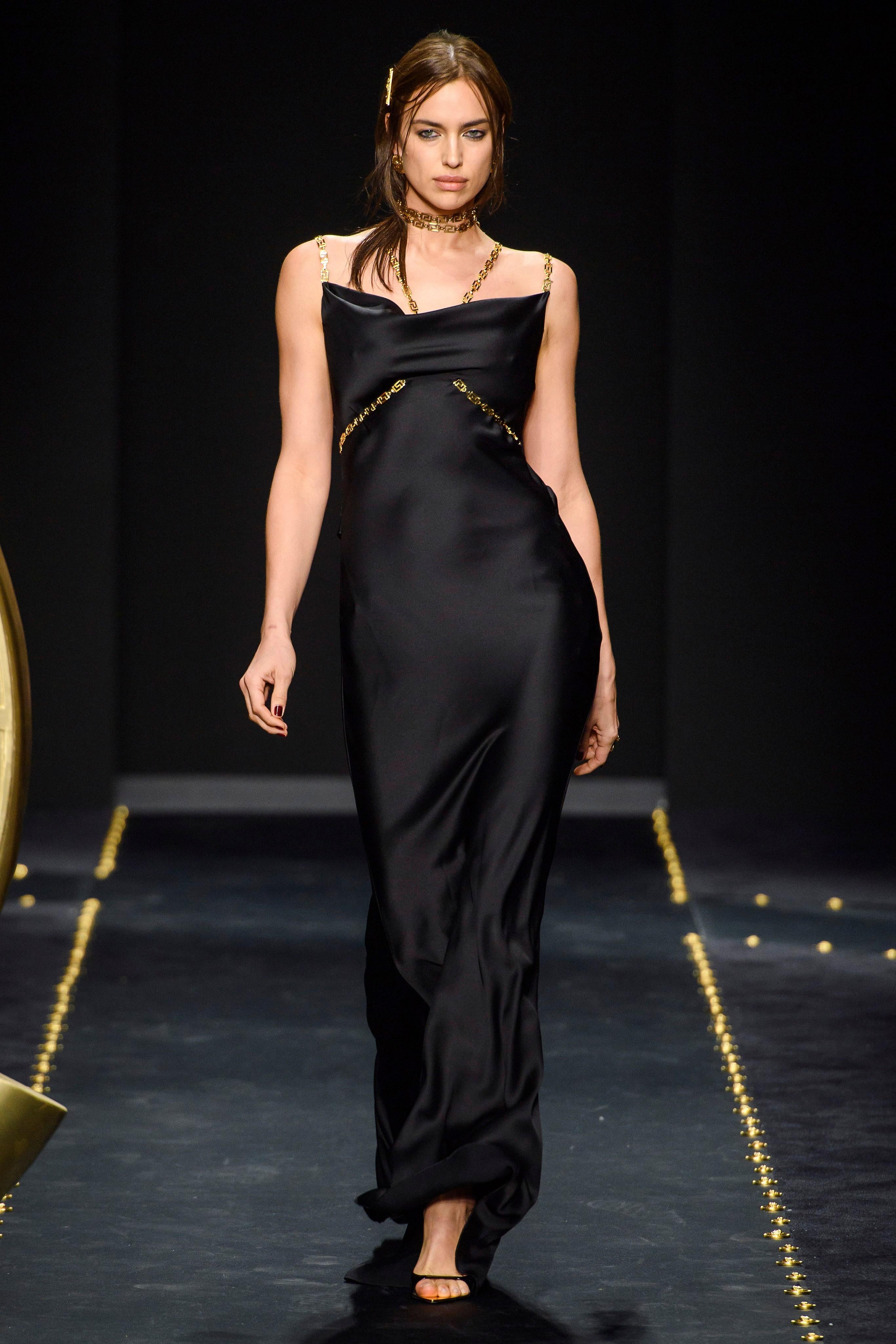  VERSACE 

Fall 2019 Look #60


The gorgeous Irina Shayk walked Versace's Fall '19 runway in this slinky black gown.



 Made in Italy from lustrous satin, it has polished gold straps (modeled after the label's signature chain motif) that snake