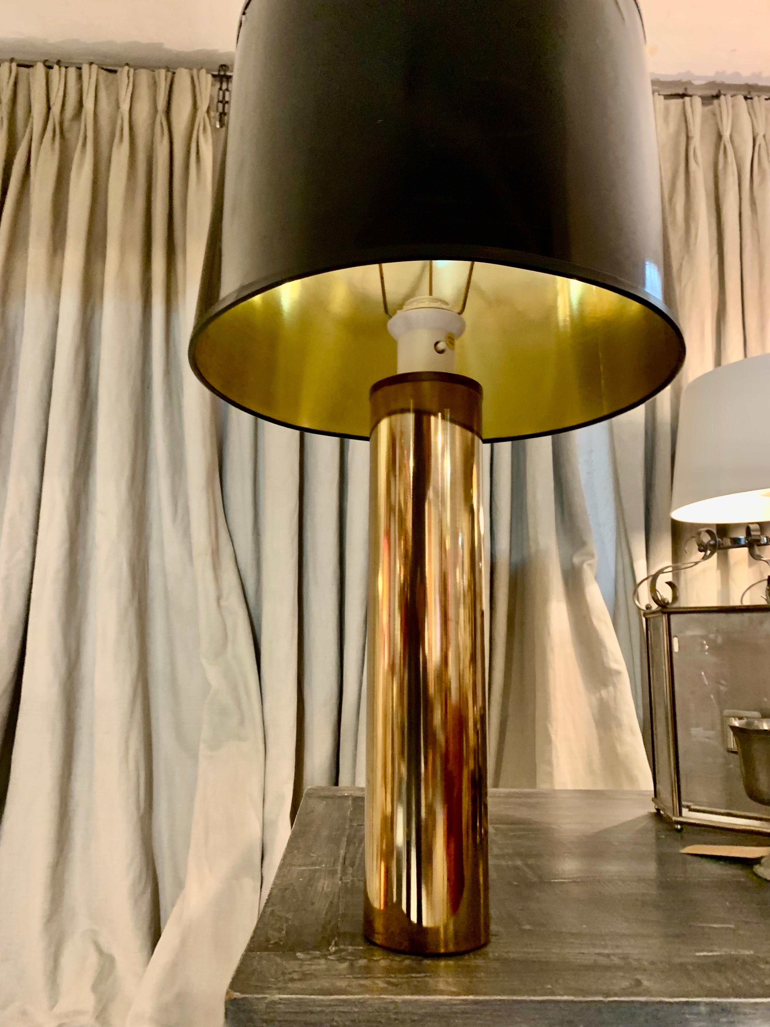 A Swedish table lamp from the 70s, made entirely of brass, is rewired and works. The lampshade is in original black patent leather and has some marks of use.