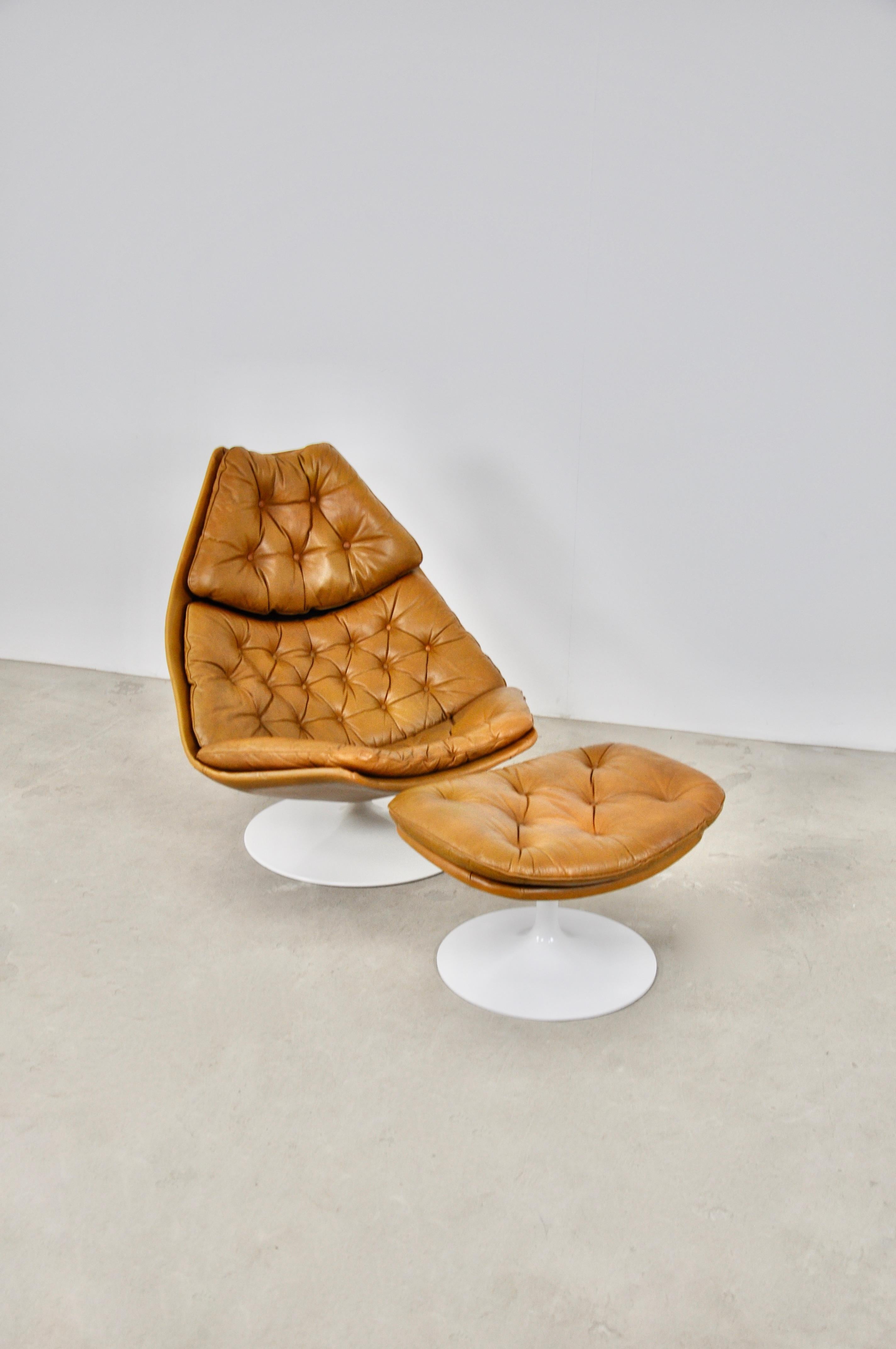 Leather armchair with ottoman. The armchair is swiveling.35cm seat height 
Ottoman dimensions: H:40cm W: 65cm D: 52cm 
Wear due to time and age of the chair (1960S).