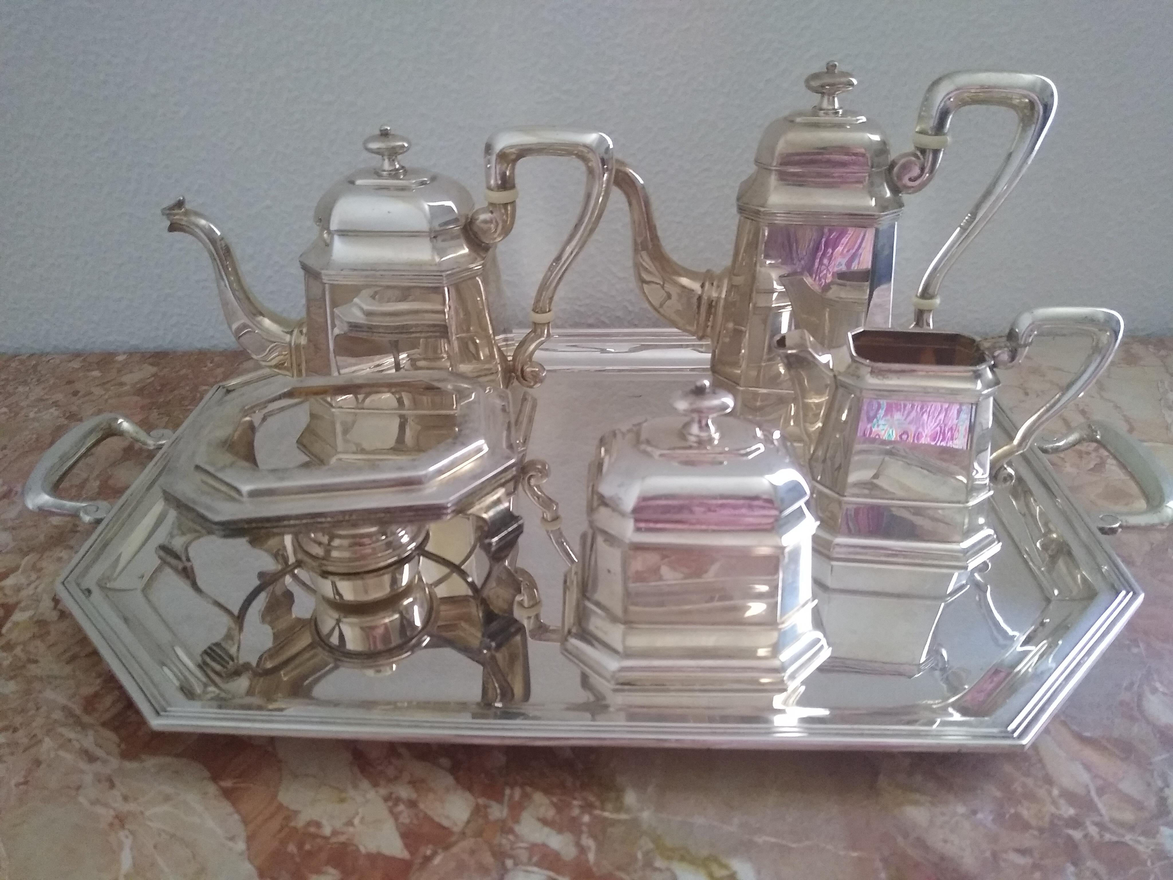 Cesa 1882 sterling silver 06-piece tea and coffee set in an elegant, geometric design reminiscent of the Art Deco style, consisting of:

 a stand with a burner, measuring cm 15 x 13 x 8.5h
a sugar bowl cm 12 x 10 x 12h
a creamer cm 16 x 8.5 x 12h
a
