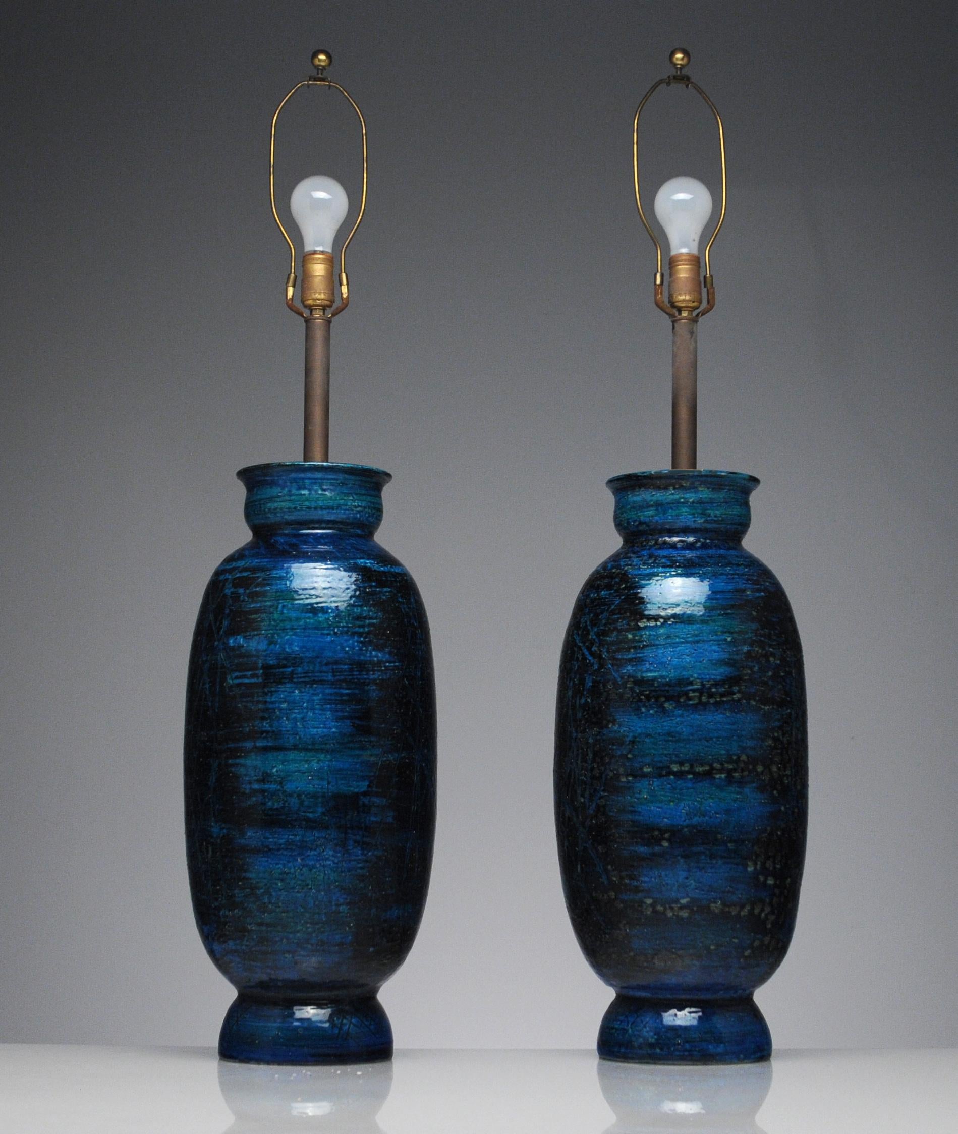 Fantastic and large pair of Italian lamps by the famed ceramicist Aldo Londi. Beautiful dark Rimini Blue glaze in the Sgraffito style. Signed to underside 1576 made in Italy. Lamps were originally purchased in New York in 1962. With shades they