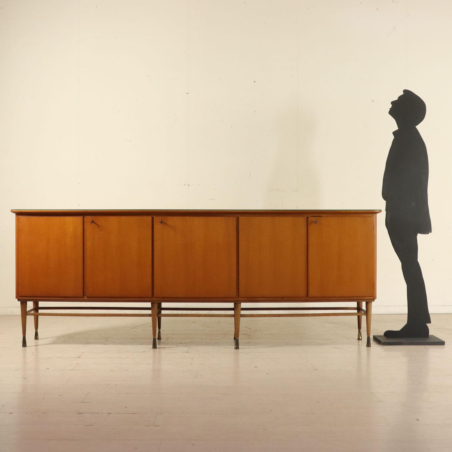 A buffet, mahogany veneer, transparent glass on the top, legs with brass ferrules. Manufactured in Italy, 1950s.