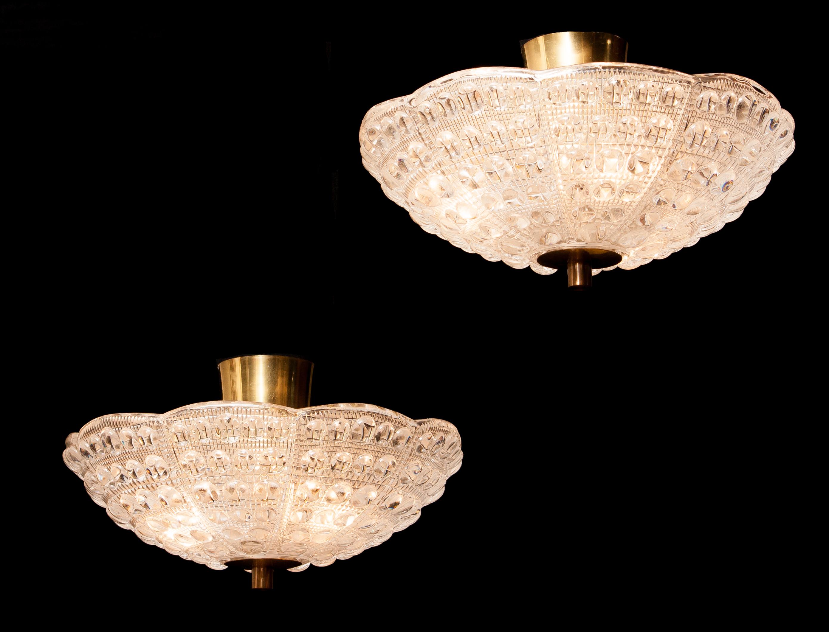 Beautiful pair of ceiling lights designed by Carl Fagerlund for Orrefors, Sweden.
These pendants are made of crystal glass and brass.
They are in wonderful working condition.
Period, 1960s.
Dimensions: H 20 cm, ø 36 cm.