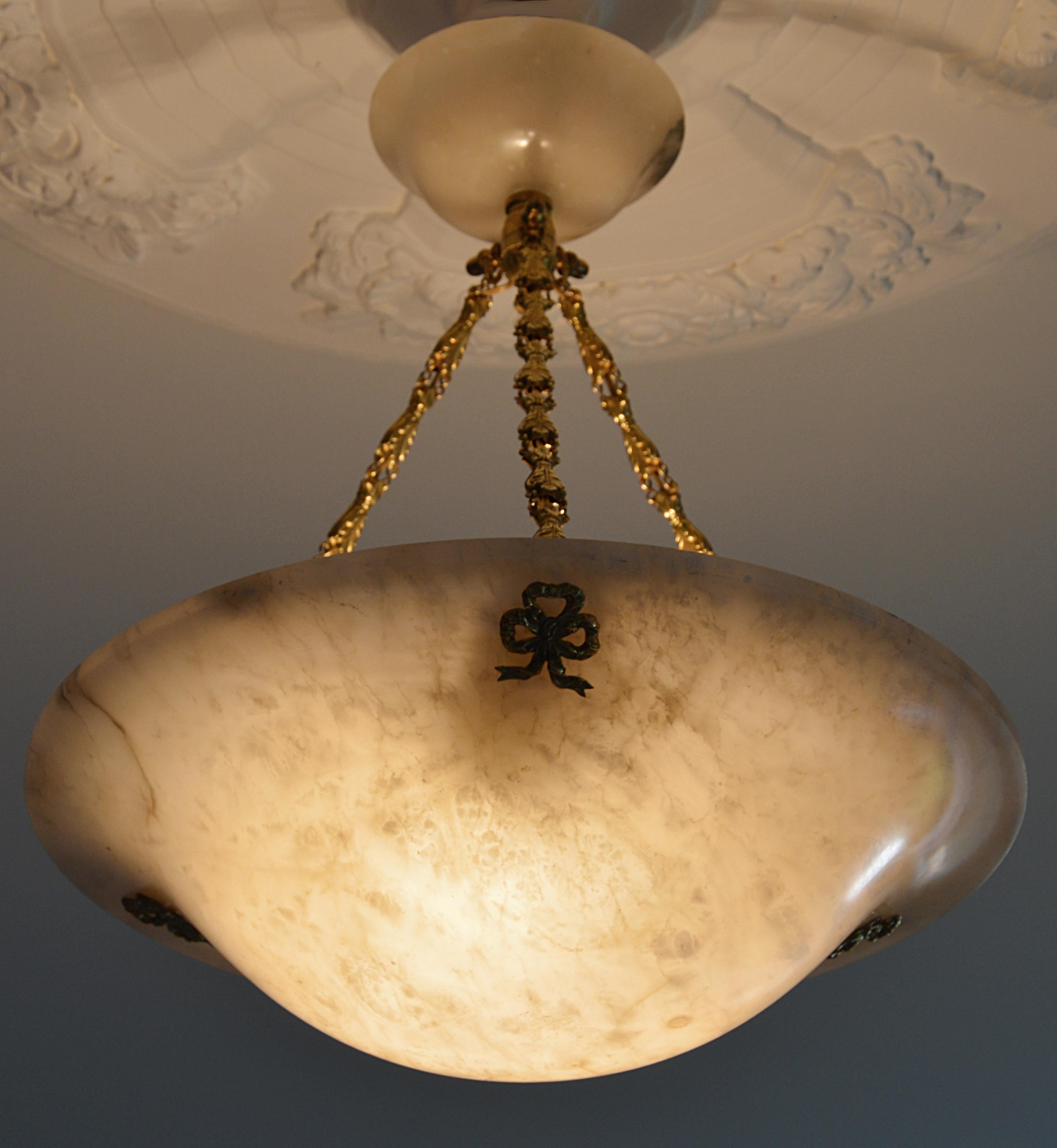 French Art Deco pendant chandelier, France, 1920s. Large thick alabaster shade hung on its original fixture. Canopy made of the same alabaster as the shade. Bronze hidden-holes and brass chains.

Welcome to our Platinum 1stDibs store ! To be