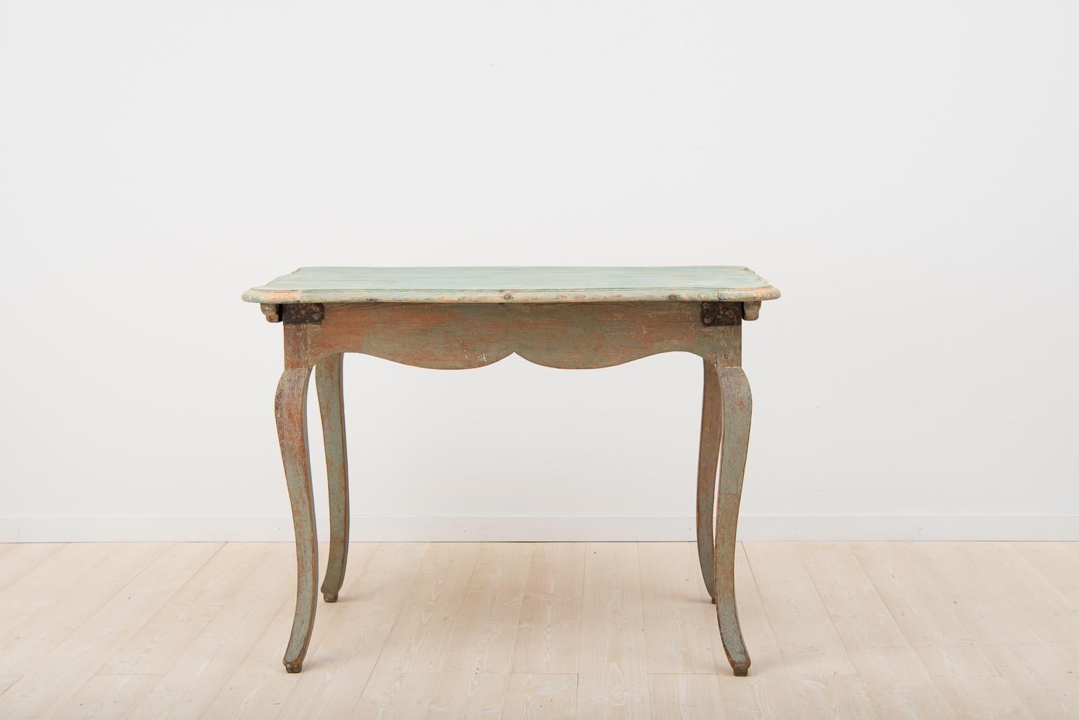 Freestanding Baroque table from northern Sweden, circa 1770 dry scraped to original paint. Painted in two tones, the tabletop is slightly lighter in color. Curved legs with feet and profiled tabletop. Older enforcements in iron in the corners – see