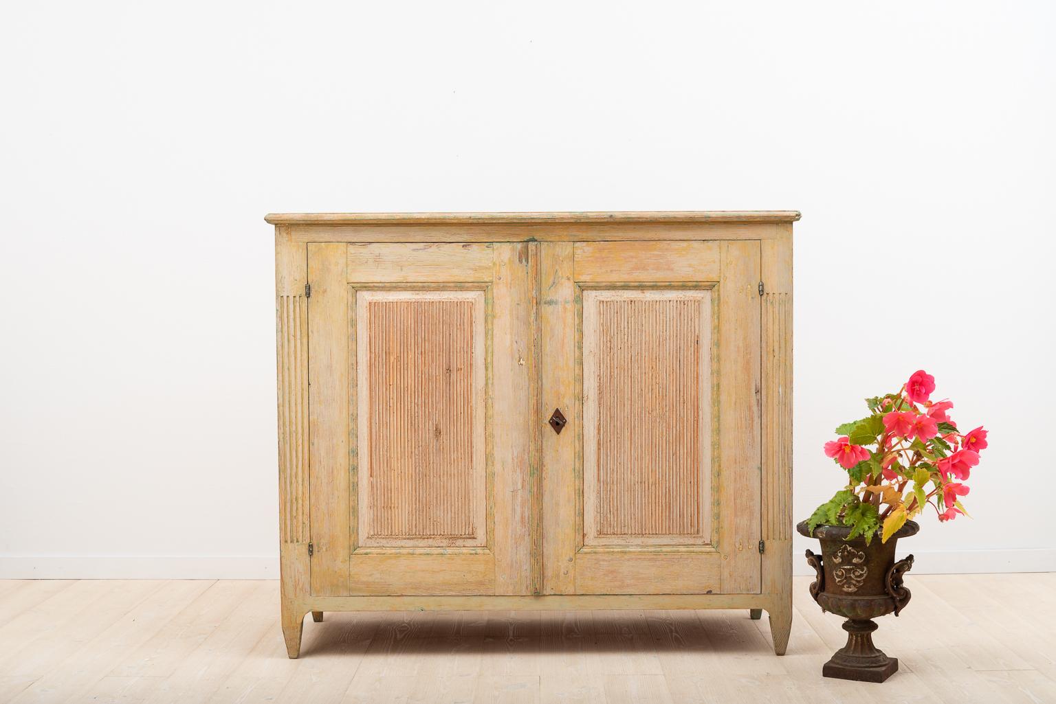 Gustavian sideboard that’s been dry scraped to original paint. Classic form with decorated doors and straight tapered legs. The top with minor touch ups. Original working lock and key. The sideboard is from an old farm located in Mellanfjärden,