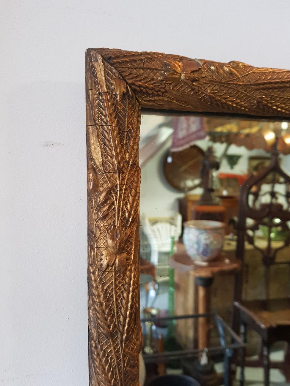 Late 19th century Dutch mirror with gilt frame decorated with ears of grain (small piece missing at the bottom).

The measurements are:
Depth 4 cm/ 1.5 inch.
Width 54 cm/ 21.2 inch.
Height 84 cm/ 33 inch.