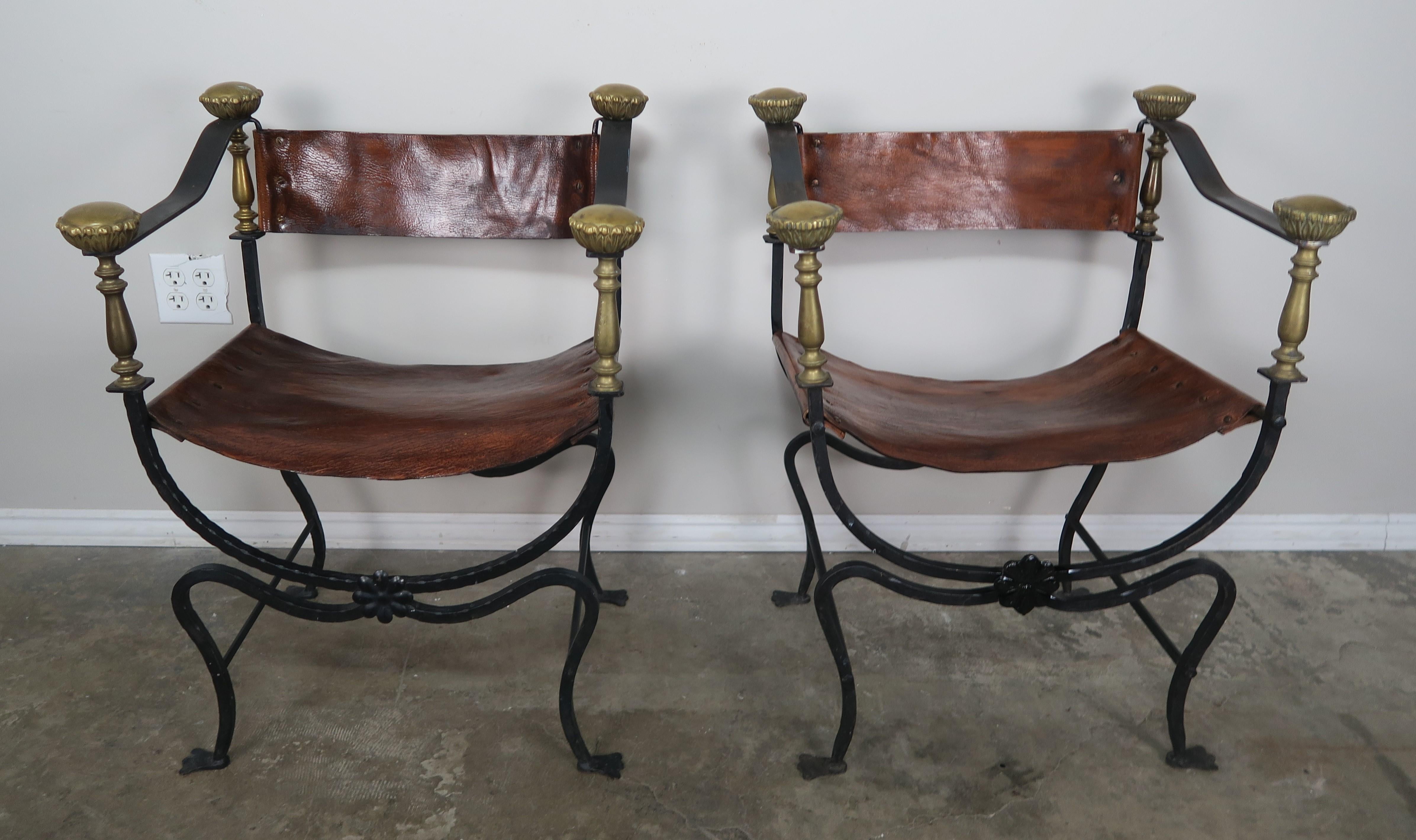 Pair of Spanish wrought iron armchairs with bronze details and leather upholstery. 
Seat height 17
